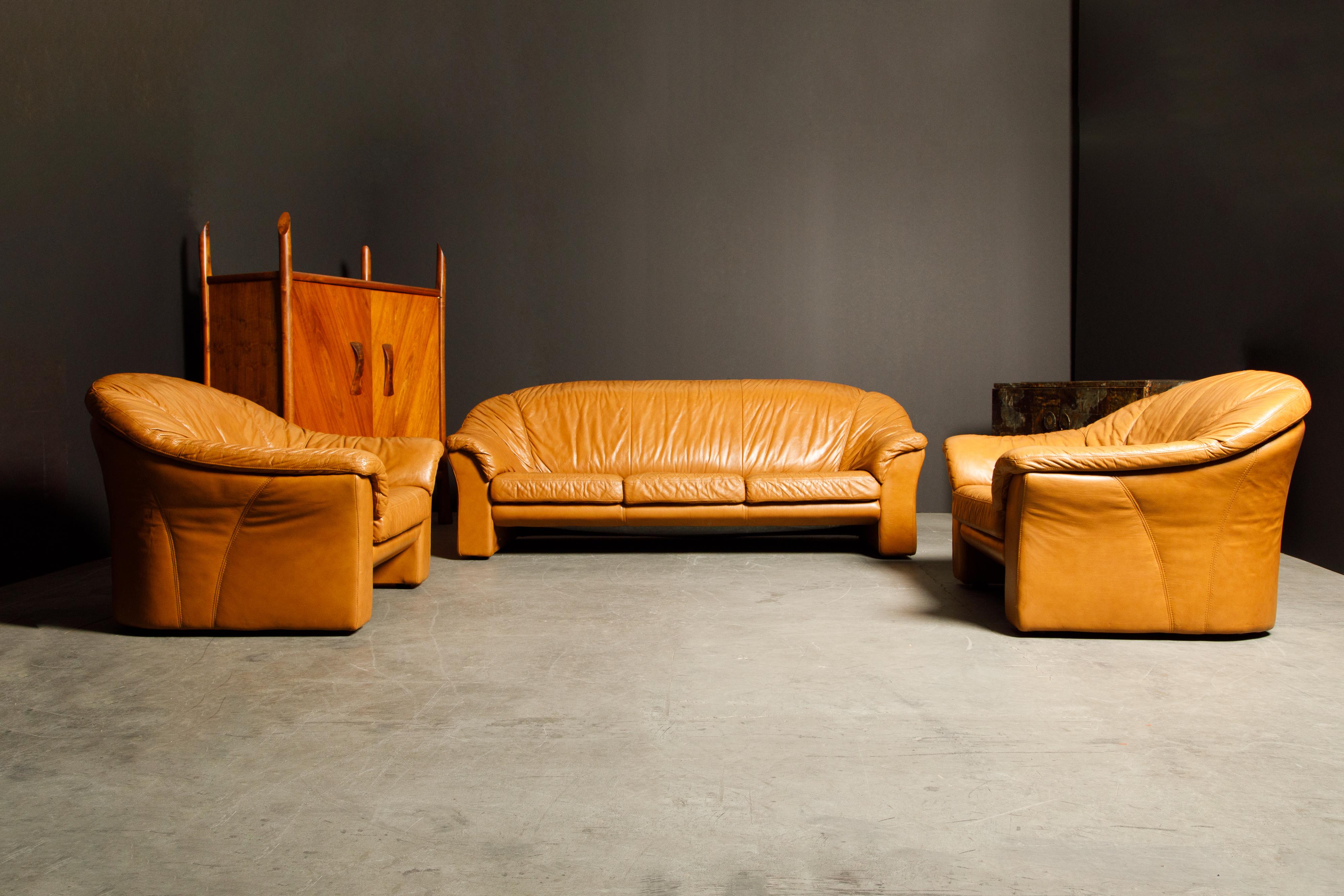 An incredibly comfortable deep seated and large scale Italian sofa and pair of lounge chairs in gorgeous lightly patinated cognac colored leather. Amazing style with the lightly aged leather which has a natural patina developed over decades of