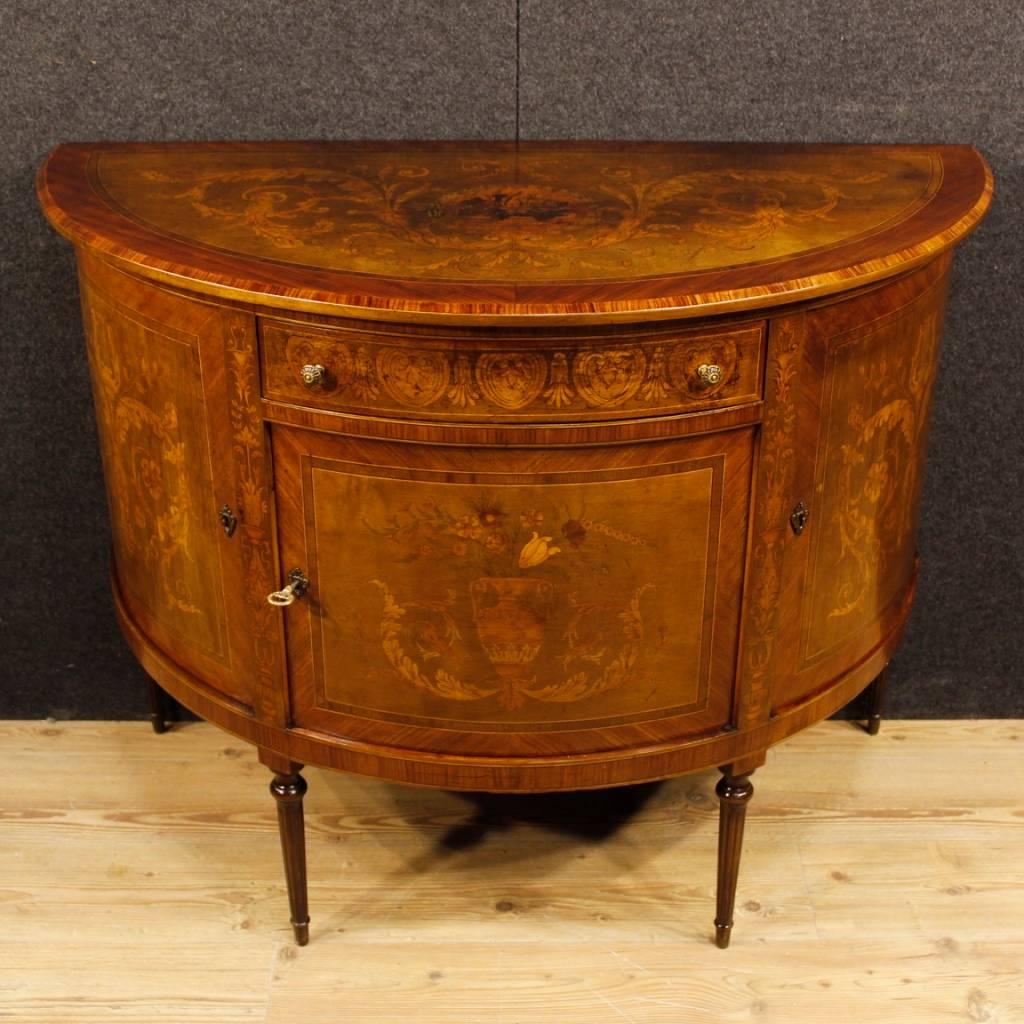 Italian sideboard of the 20th century. Louis XVI style furniture richly inlaid in various woods of excellent quality. Demilune sideboard with three doors and a frontal drawer of good capacity. Top in character, also finely inlaid, which has some