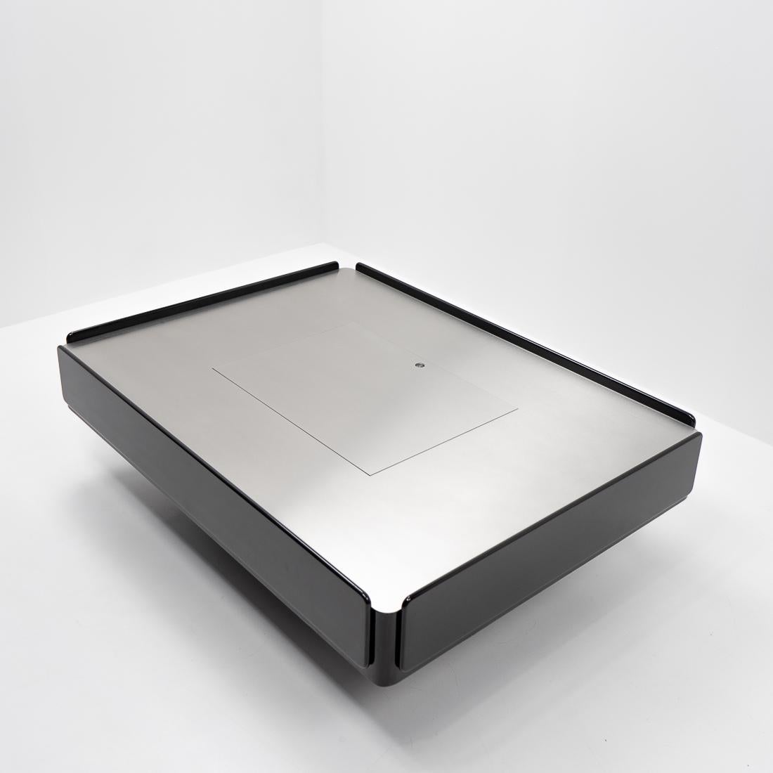 A Caori coffee table by the Italian designer Vico Magistretti for Gavina, produced during the 1960s in Italy. 

The black lacquered wooden base has on each side practical storage compartments with one central storage box containing a storage space