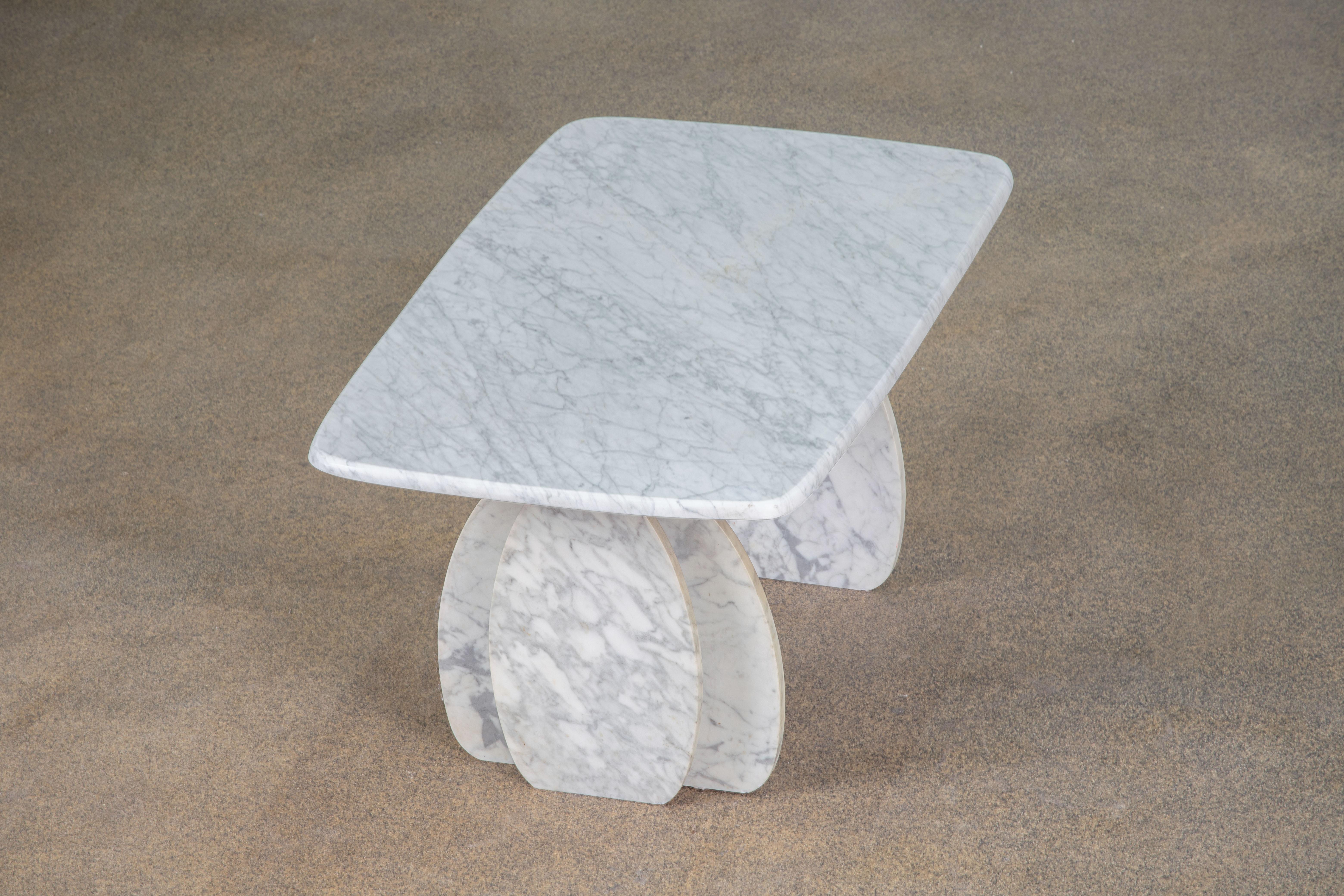 Beautiful white marble table.

The heavy eye-shaped top rests on two marble V blocks.
