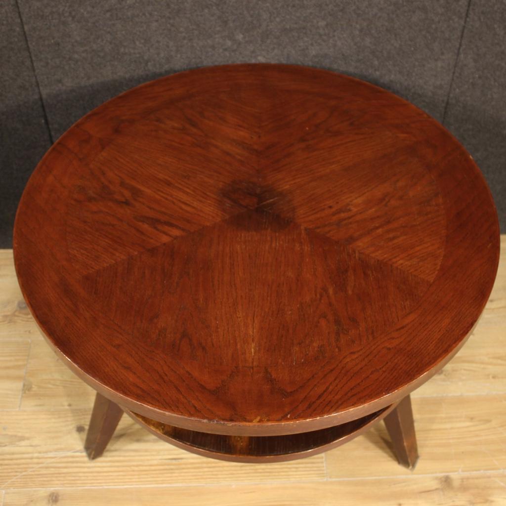 Low table of Italian design from the 1960s-1970s. Furniture of particular line and construction carved in wood beech tree. Living room table of good solidity supported by three feet and central stem (see photo) that divides the two shelves. Mobile