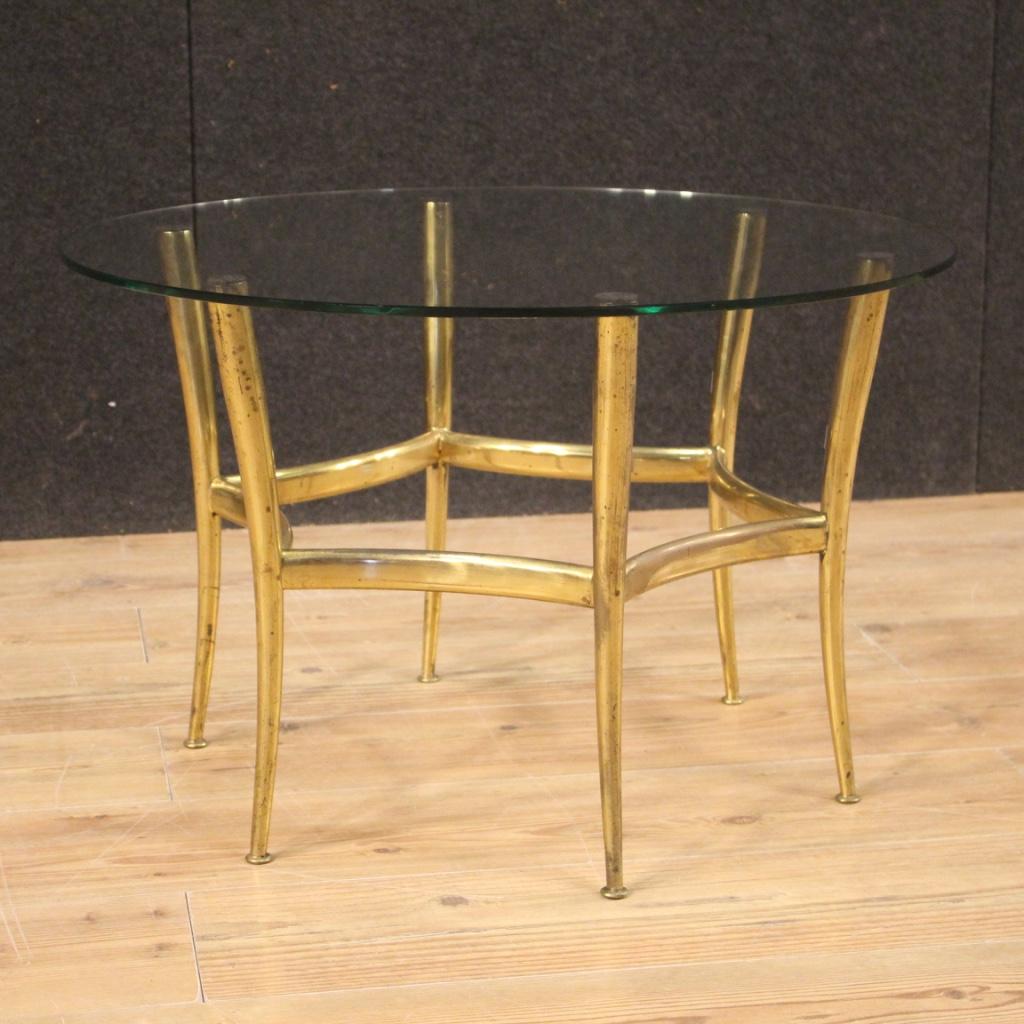 Mid-20th century Italian design coffee table. Brass cabinet gold resting on 6 curved legs and glass top in good condition, with some small scratches or signs of wear. Low table ideal to be placed in a living room but can be positioned in different