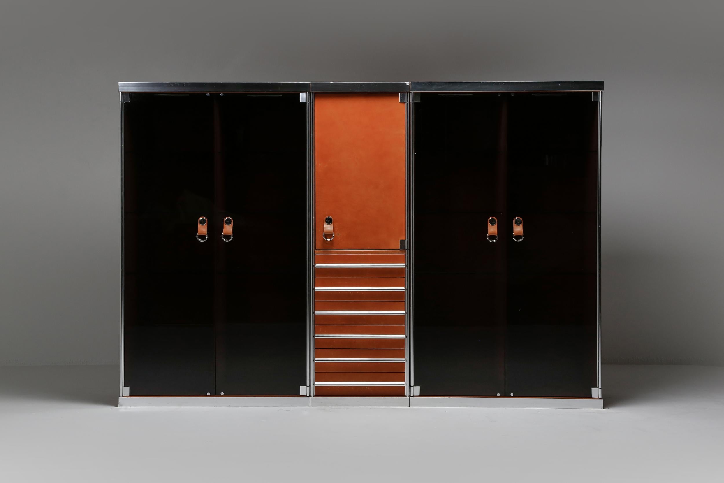 Guido Faleschini showcase, dresser, designed for the Hermès shop in Paris, Mariani Italy 1970s

consisting of one Hermès cognac leather drawer chest with shelves, flanked by two showcases with glass shelving and lights, finished with chromed steel