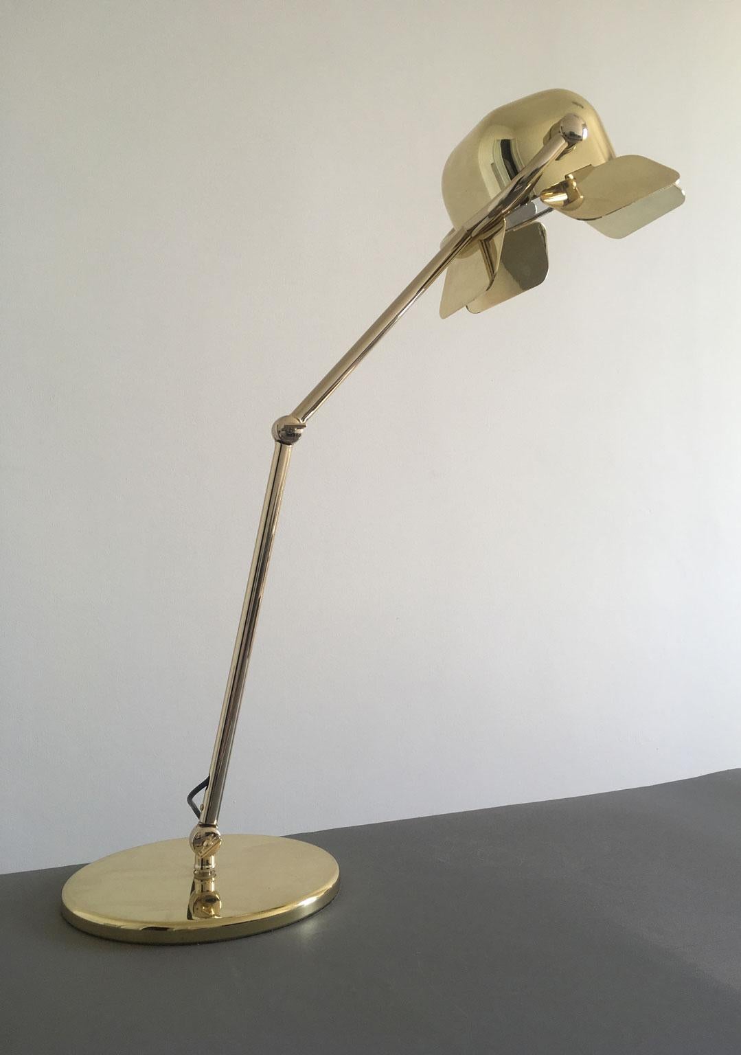 Lampe de table en laiton et aluminium fabriquée par Ghidini 1961 et conçue par Nica Zupanc. Cette lampe au design moderne où la lumière est projetée à travers quatre volets réglables et la structure fine en acier donne une touche d'élégance