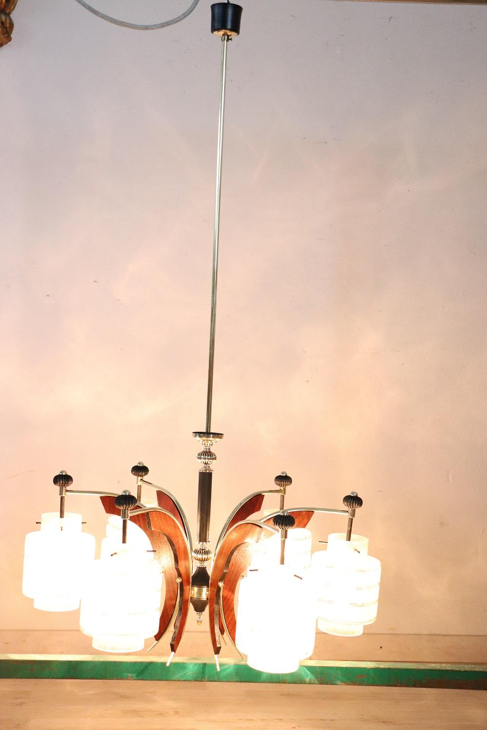 Bellissimo lampadario di design italiano in stile stilnovo con viti in vetro, metallo laccato nero, legno e ottone dorato anni '50, per un totale di sei luci. Restaurato, perfettamente funzionante.