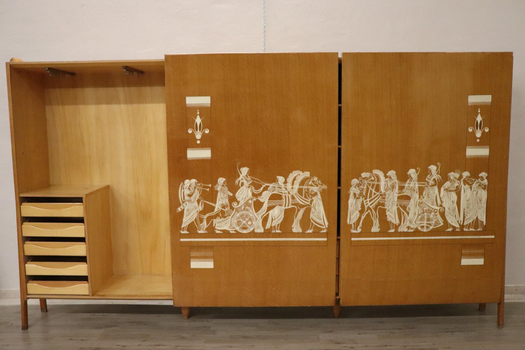 Spectacular large Italian design wardrobe from the 1960s. Large size with two sliding doors, large useful space with internal drawers. The wardrobe is characterized by a splendid hand painted decoration on the doors. A ancient Romans inspired hand