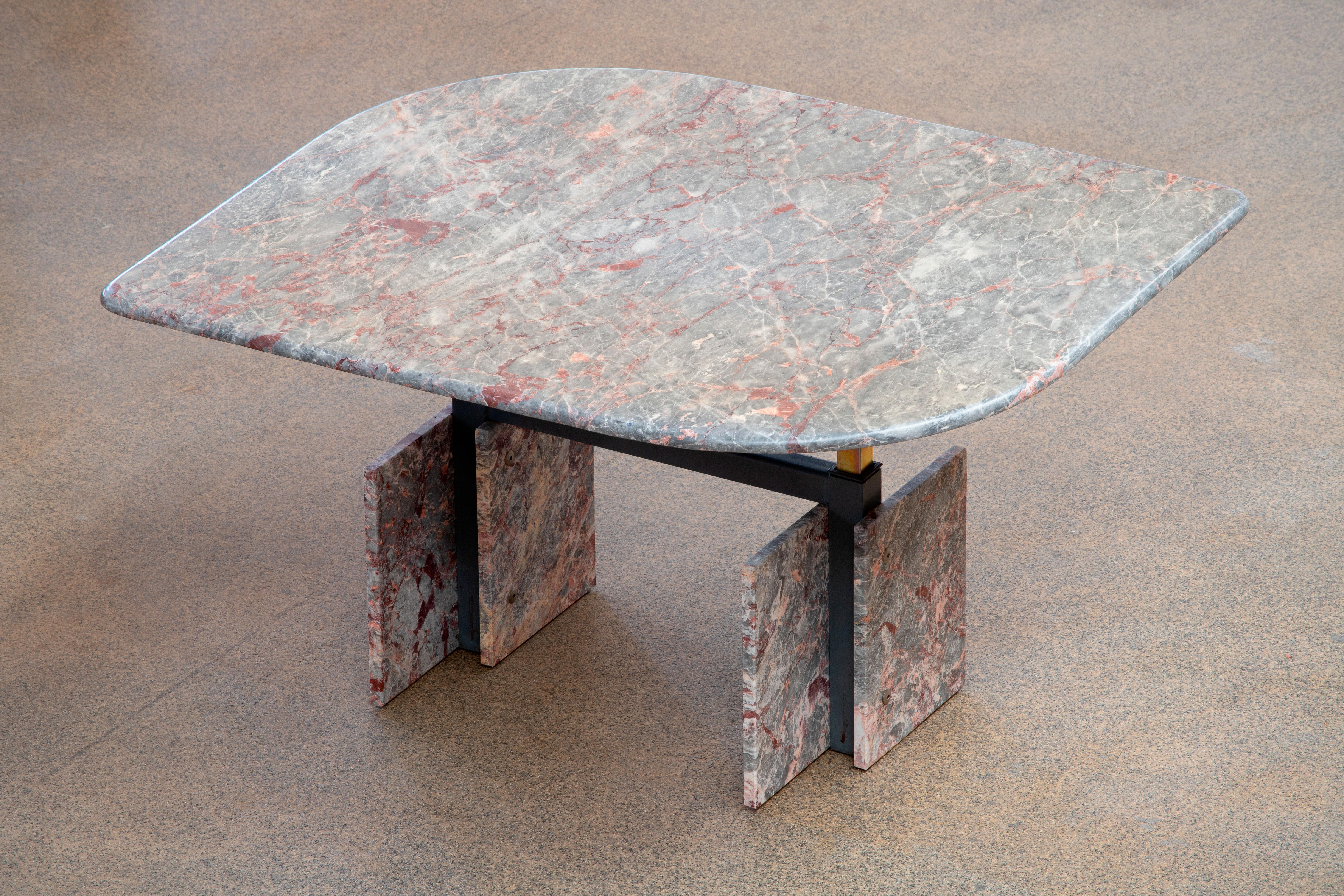 Beautiful grey, beige and pink marble table.

The heavy eye-shaped heightenable top rests on four marble blocks with a metal structure between.
