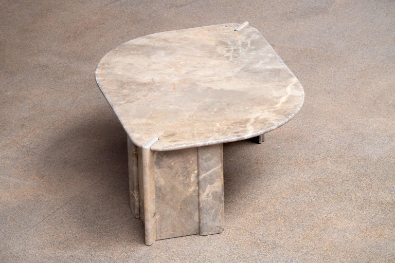 Beautiful grey, white and yellow marble table.

The heavy eye-shaped top rests on two marble V blocks.