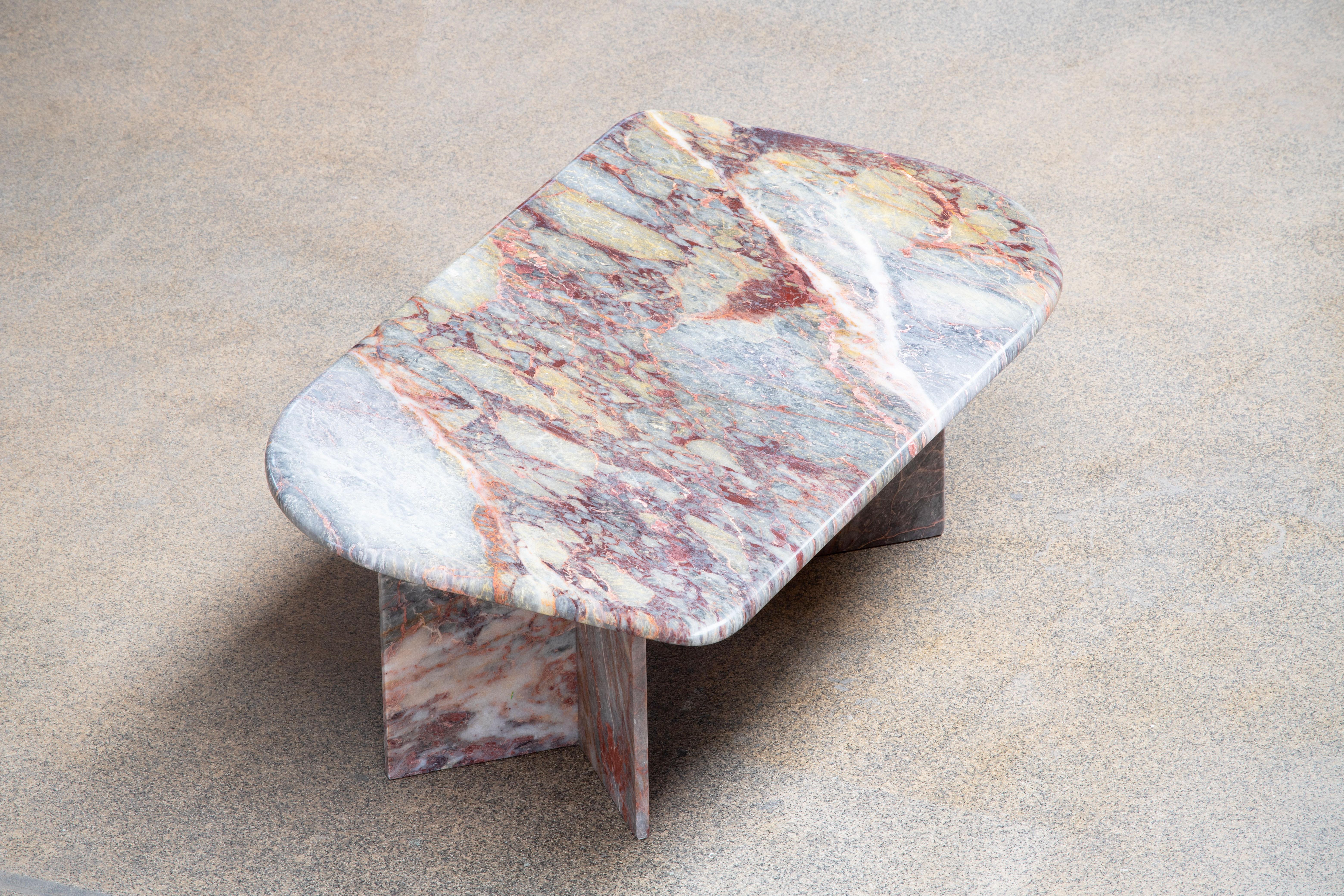 Beautiful grey, white and red marble table.

The heavy eye-shaped top rests on two marble V blocks.