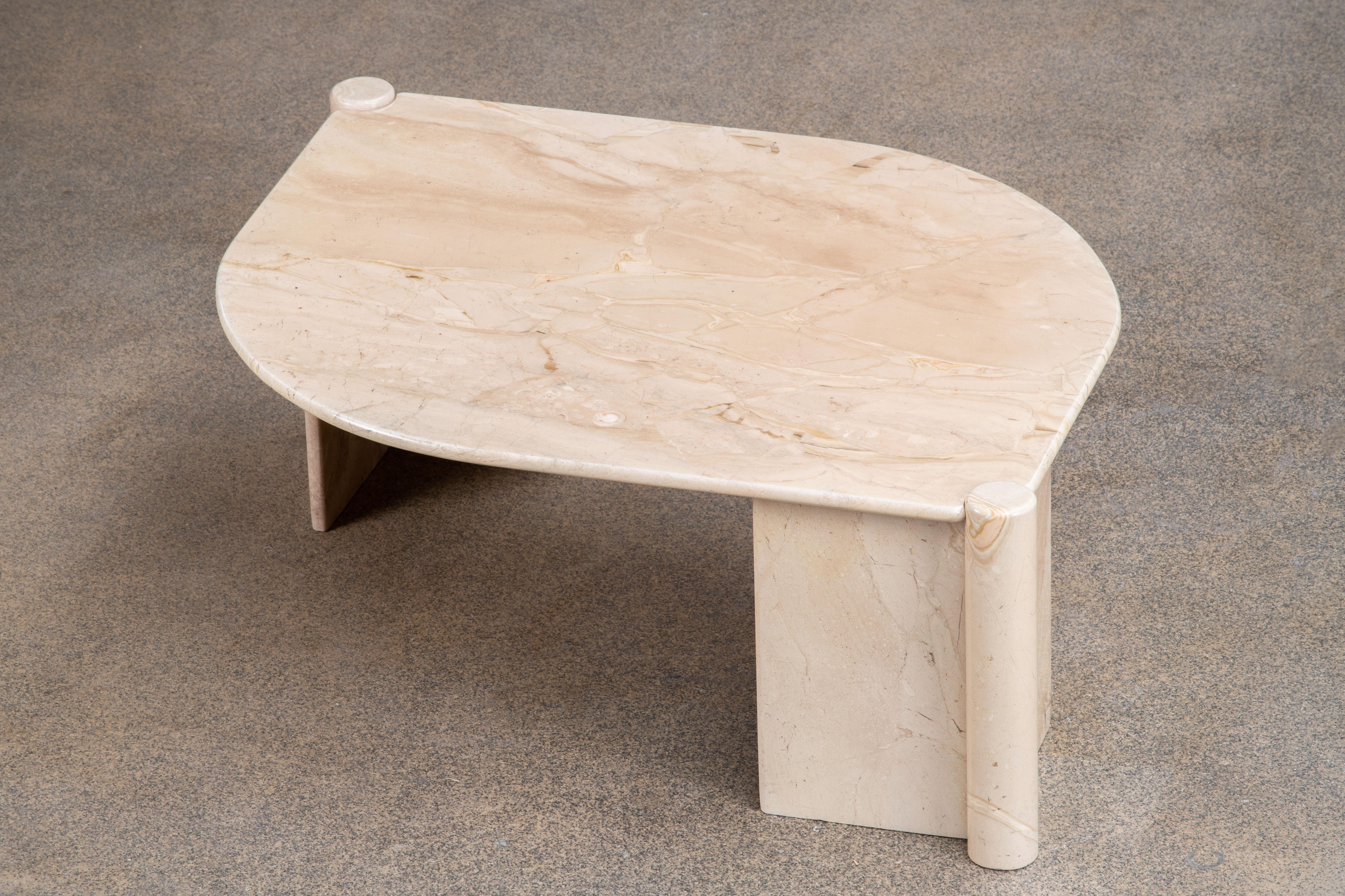 Belle table en marbre gris, blanc et rose.

Le lourd plateau en forme d'œil repose sur deux blocs en V en marbre.