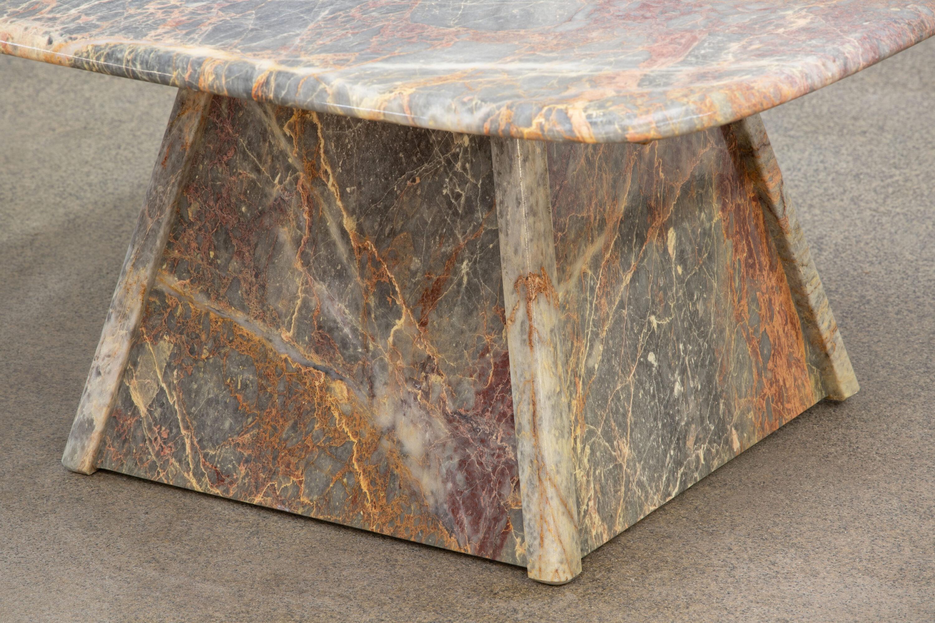 Beautiful grey, white and orange marble table.

The heavy eye-shaped top rests on two marble V blocks.