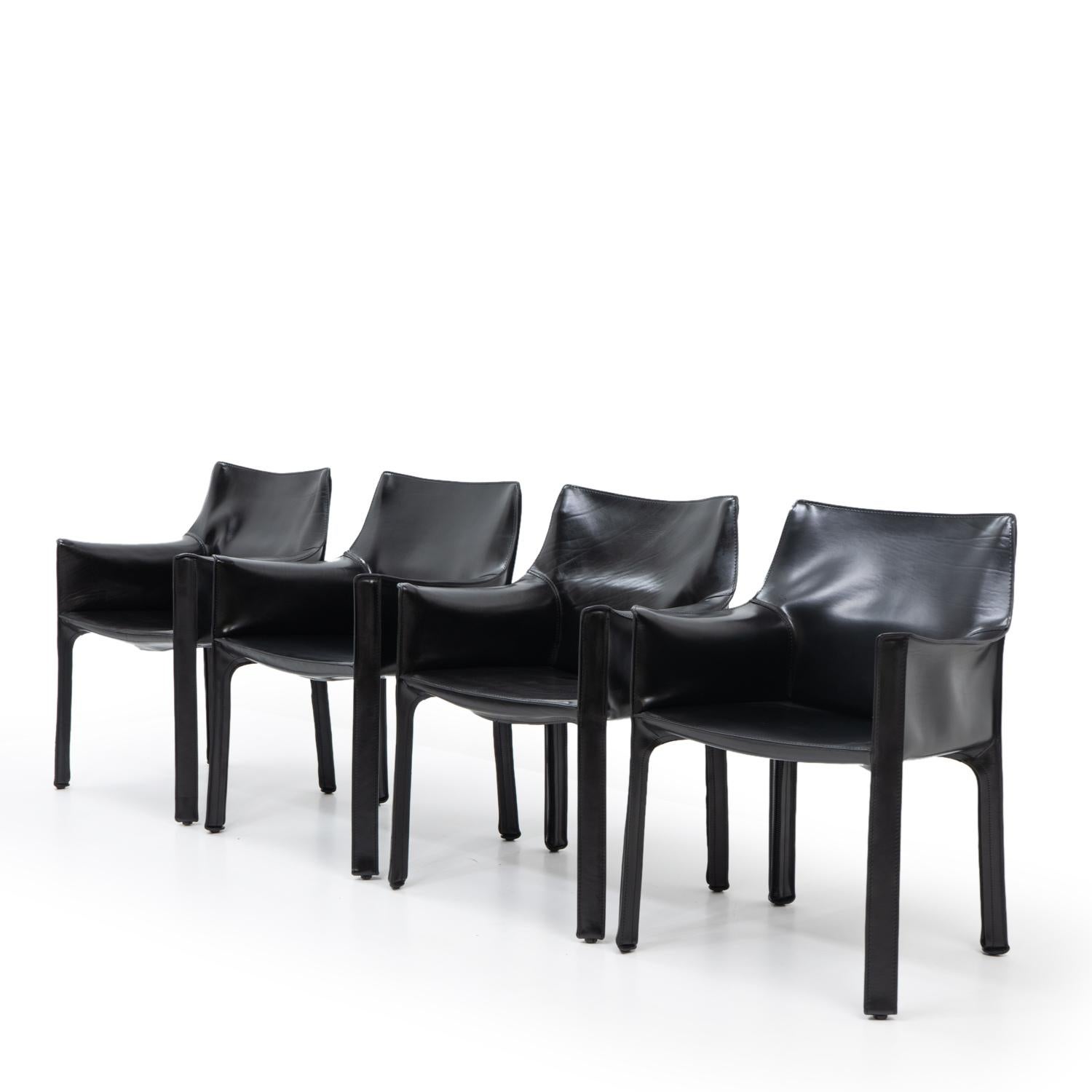 Cab 413 arm chairs in black leather by Mario Bellini for Cassina:

The Cab chair is built up as a tubular frame over which thick saddle leather is fitted; the leather skin is kept in place with zippers on the inside legs.

A wonderful piece of