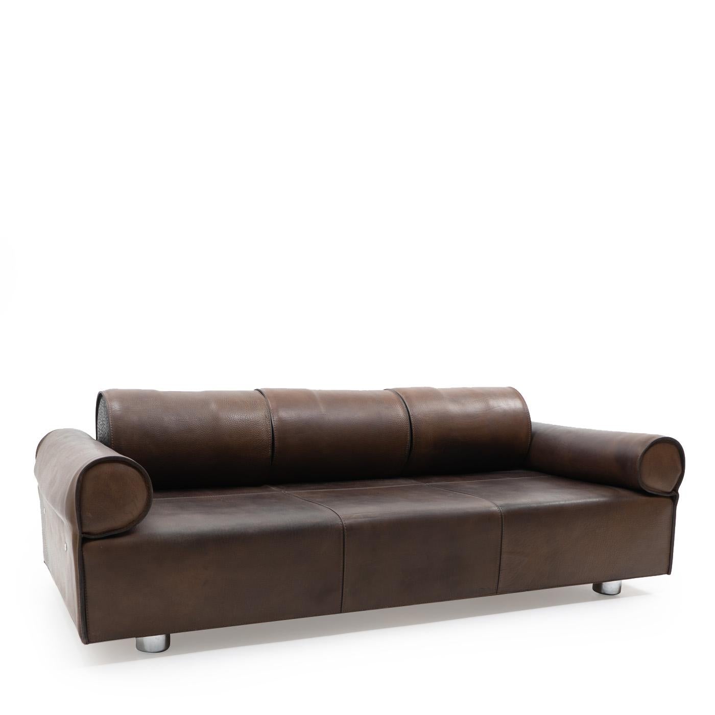 An exceptional three seater sofa, executed in thick and very heavy buffalo hide; the aged leather shows a wonderful deep dark-brown patina, it remains in excellent condition, with some discolouration and normal signs of use.

The sofa can be