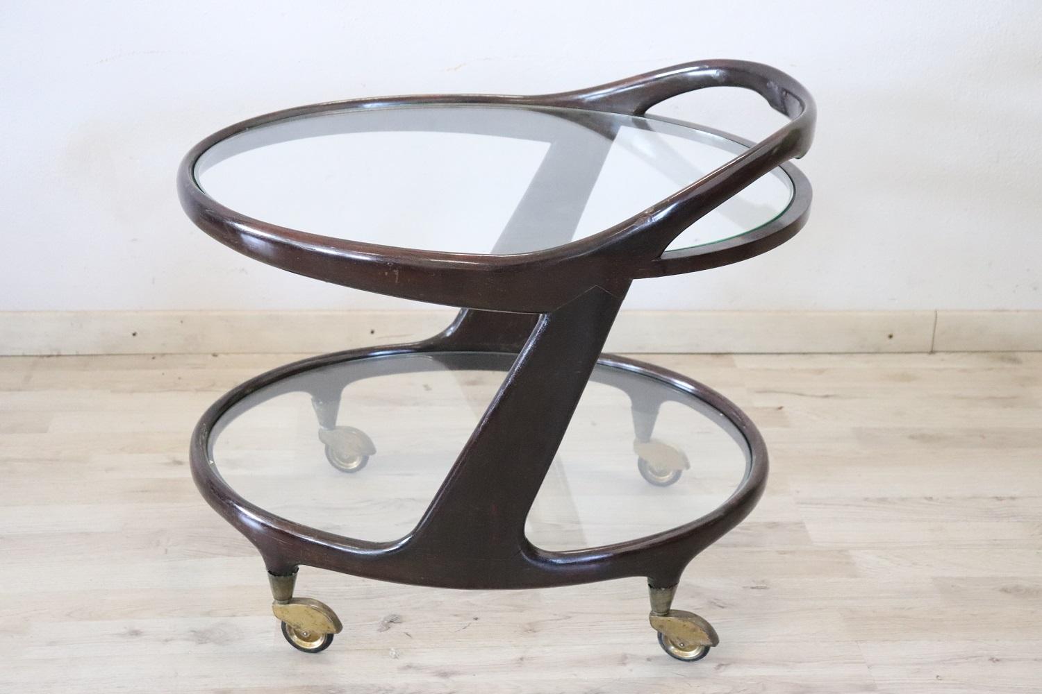 Rare 1950s Italian desgin by Cesare Lacca serving bar cart. Made of curved beech wood equipped with two glass shelves and brass wheels for convenient movement. Perfect for serving drinks to your guests.