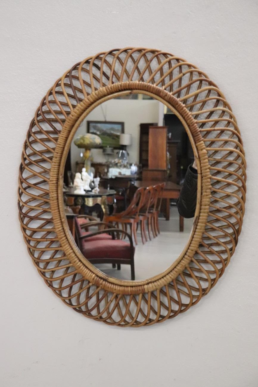 Siamo entusiasti di presentare questo squisito specchio ovale in stile Costa Azzurra, meticolosamente realizzato in bambù curvato e rattan intrecciato. Disegnato dal famoso Franco Albini in Italia e prodotto da Bonacina intorno agli anni '60, questo