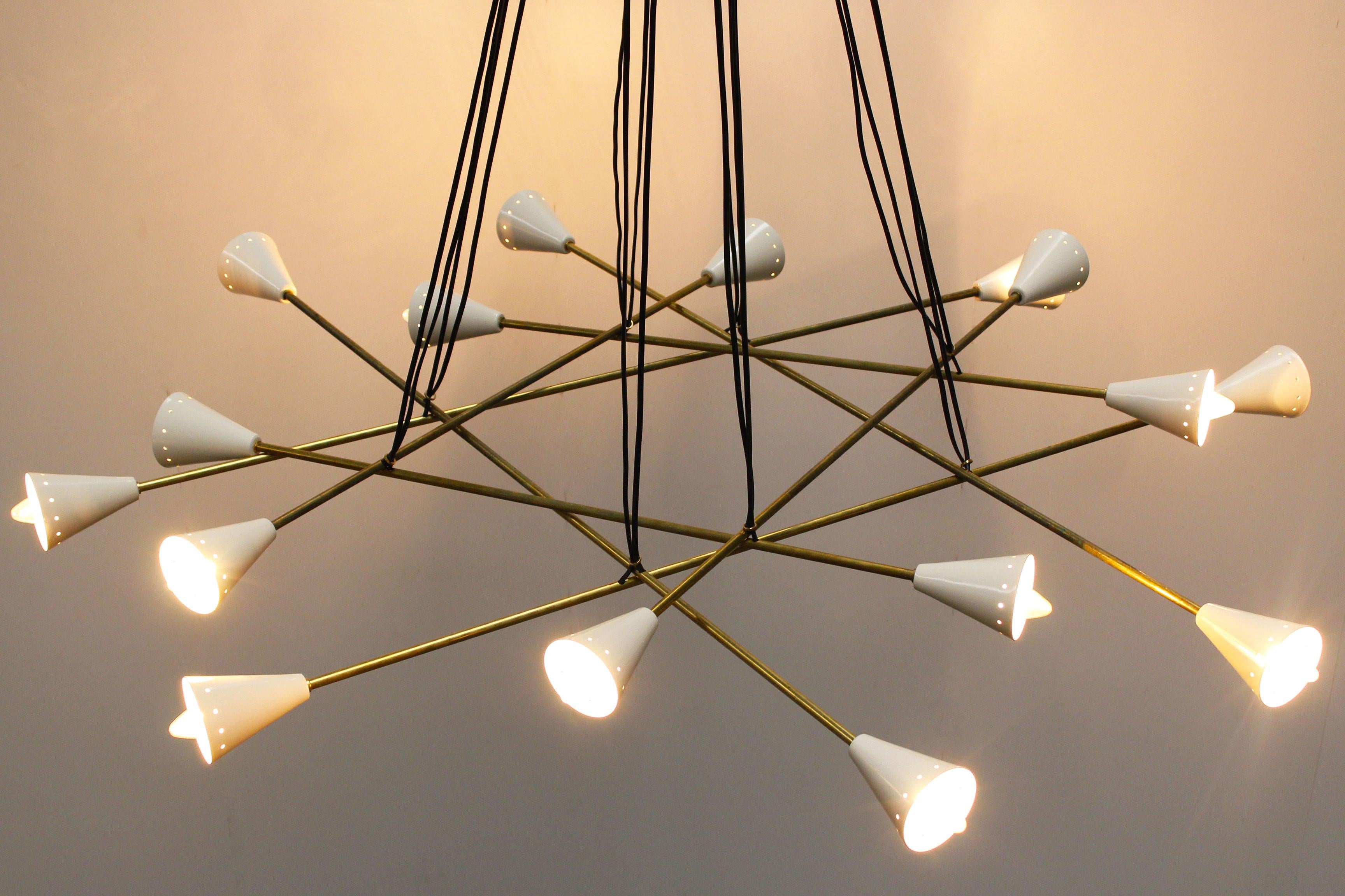 Massive cluster chandelier designed by Stilnovo with a diameter of 130 cm. The chandelier has 16 sockets, the chandelier has a brass frame and white metal shades hanging on black wires. Its Minimalistic shape make it great for any midcentury or