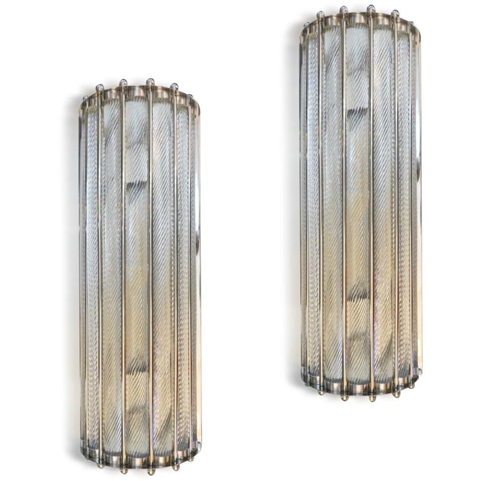 Contemporary customizable Italian Art Deco Design pair of semi-circular wall lights, entirely handcrafted, with a polished nickel finish. The nicely scalloped airy structure supports crystal clear Murano glass rods worked with the sophisticated