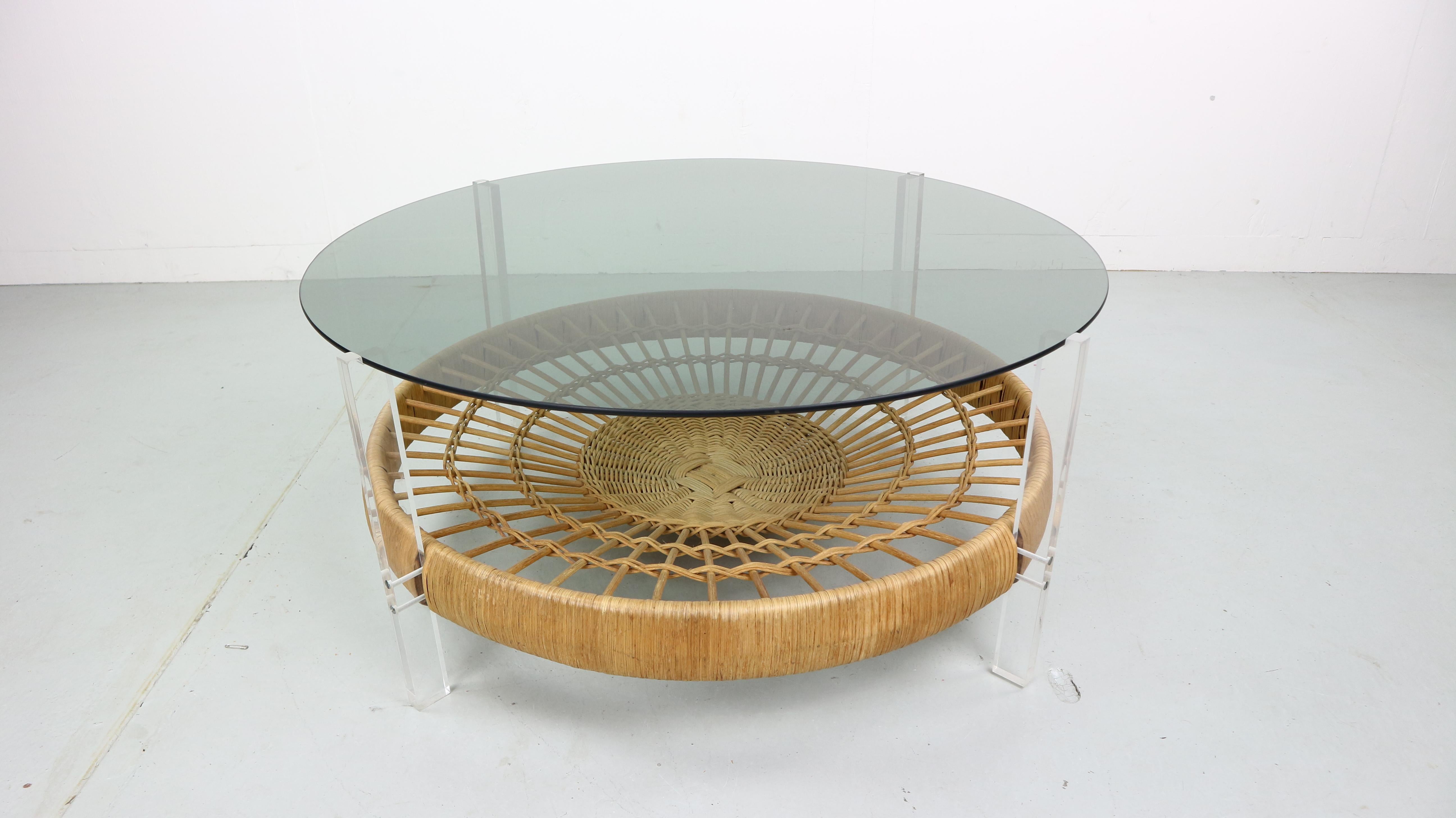 Rattan and glass coffee table from the 1970s, Italy.
This table has great round form, contracting materials work in harmony to create a real showcase piece that would compliment any mid century interior. It features a Lucite frame with a smoked