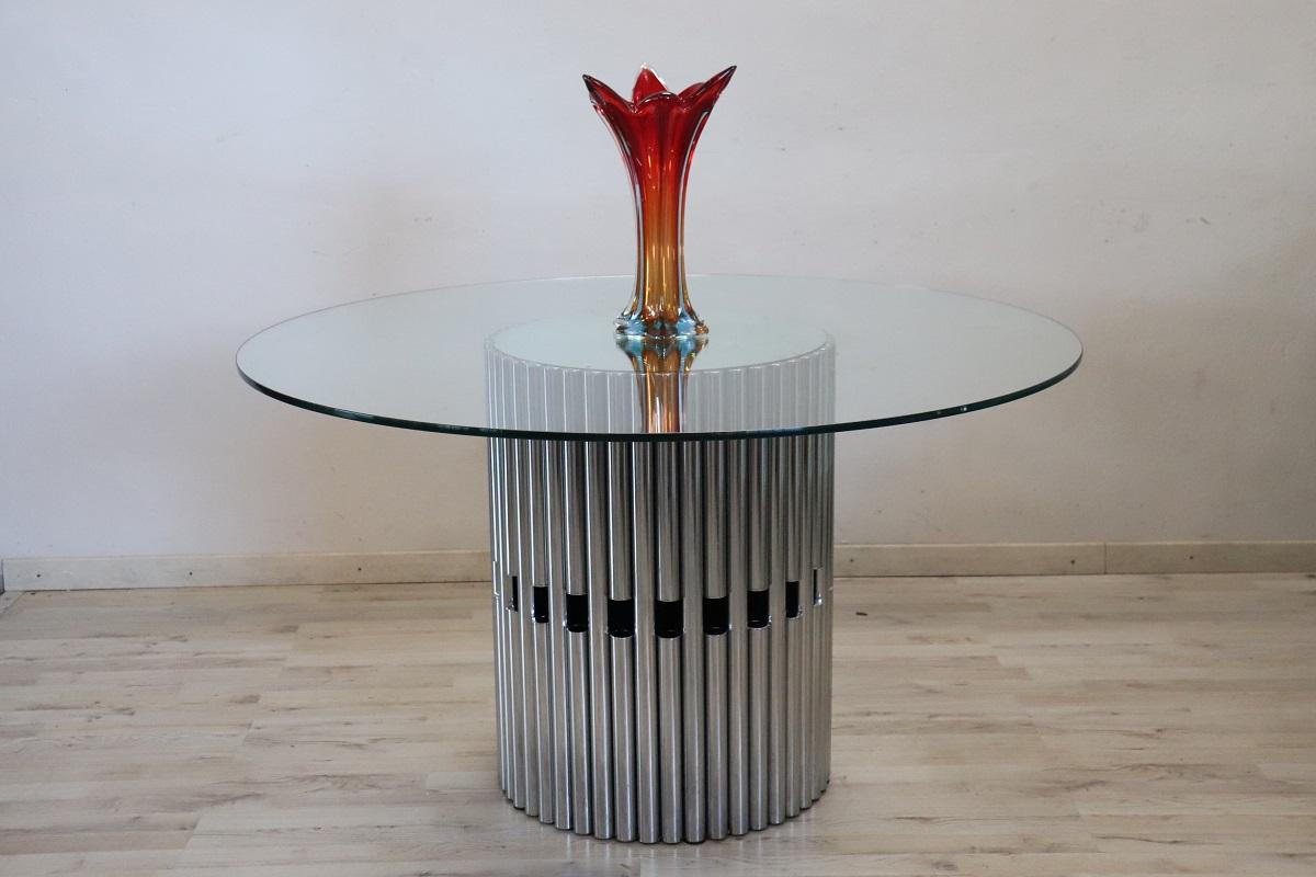 We offer this spectacular Italian dining or centerpiece table by Gastone Rinaldi, circa 1970 (no trademark or signature present).

Its design is truly unique, with a chromed tubular steel base and a thick, clear glass top. The original mirrored