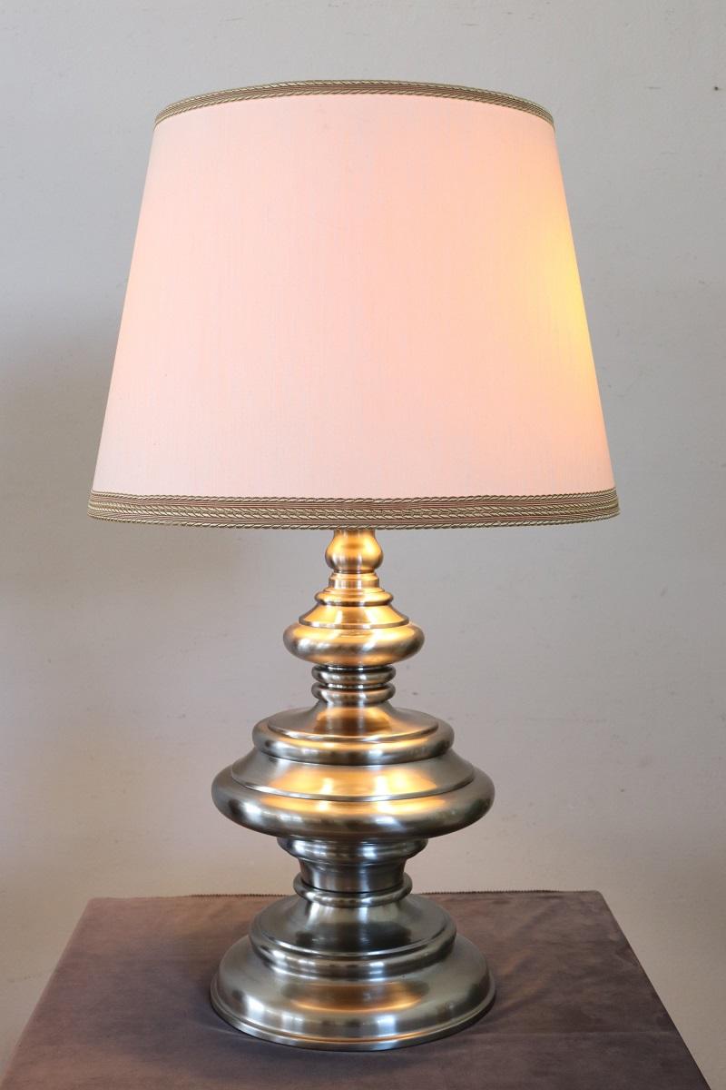 Ti presentiamo questa splendida lampada da tavolo, realizzata in Italia negli anni Settanta. La lampada è realizzata in acciaio satinato e cromato.
Il paralume si abbina perfettamente alle linee della lampada e il tessuto leggero e senza fronzoli