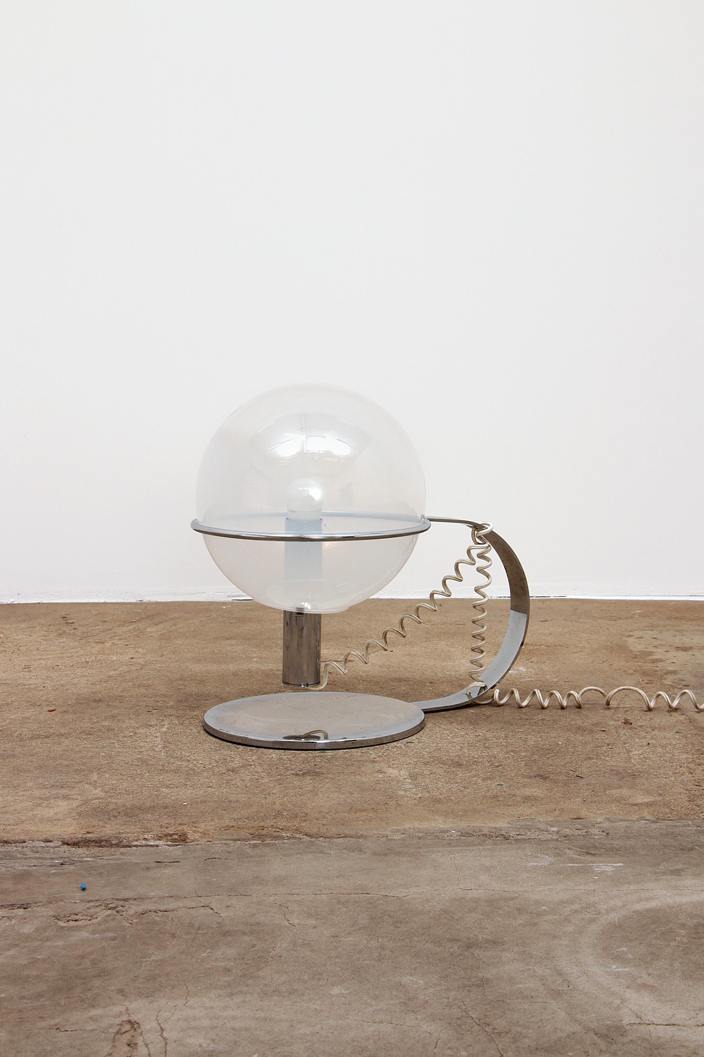 Belle lampe de table en chrome avec un anneau dans lequel s'illumine une sphère de Murano soufflée à la bouche.

Vous pouvez jouer avec cette ampoule et la placer différemment pour obtenir une lumière différente. Un interrupteur se trouve également