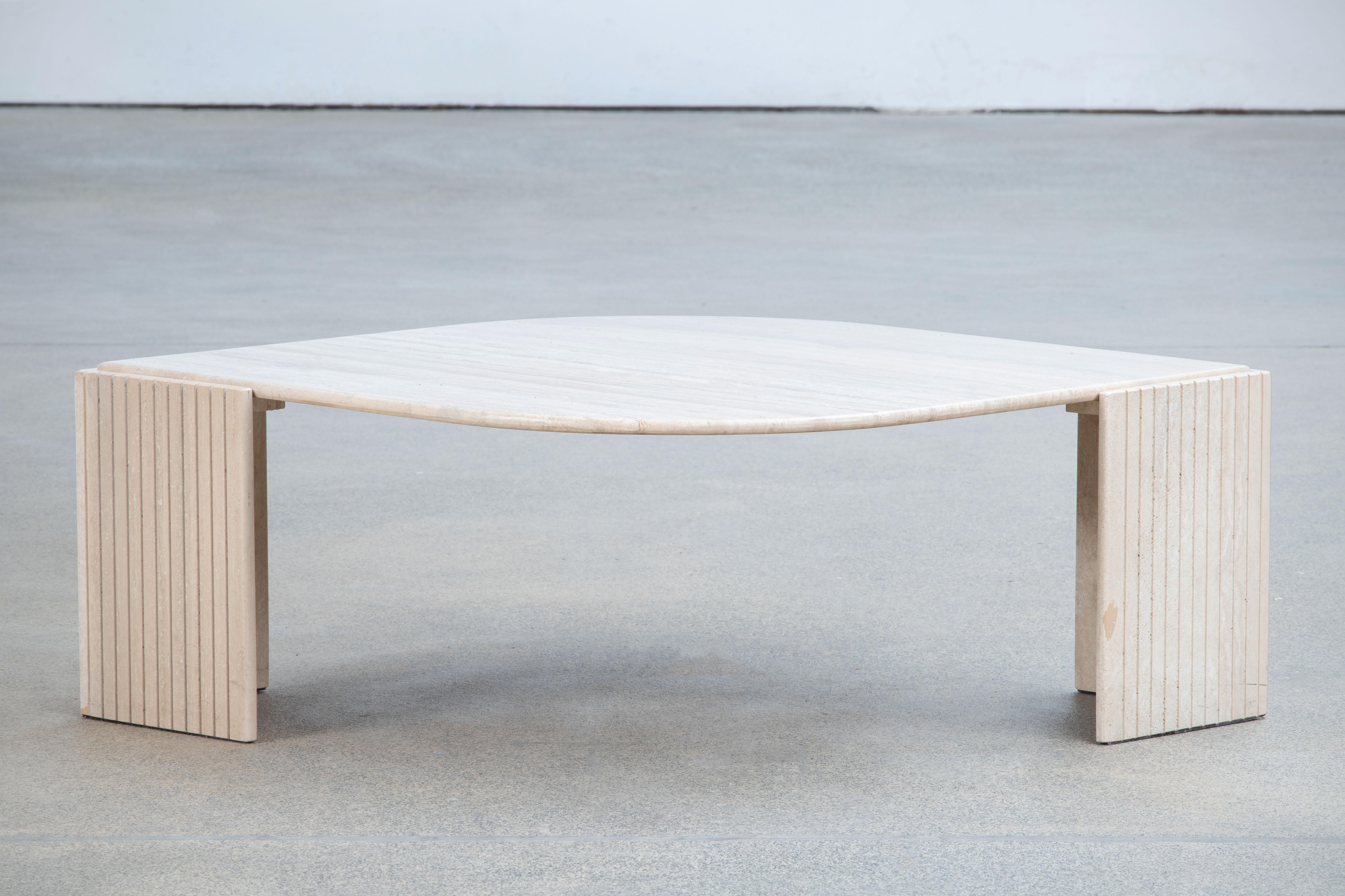 Beautiful travertine coffee table.

The heavy eye-shaped top rests on two marble V blocks.