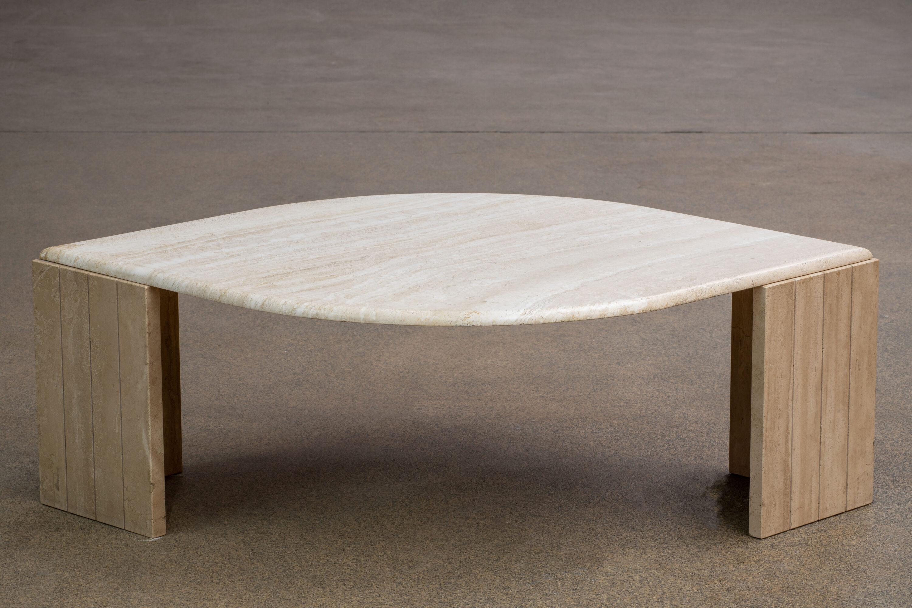 Beautiful travertine table.

The heavy eye-shaped top rests on two marble V blocks.