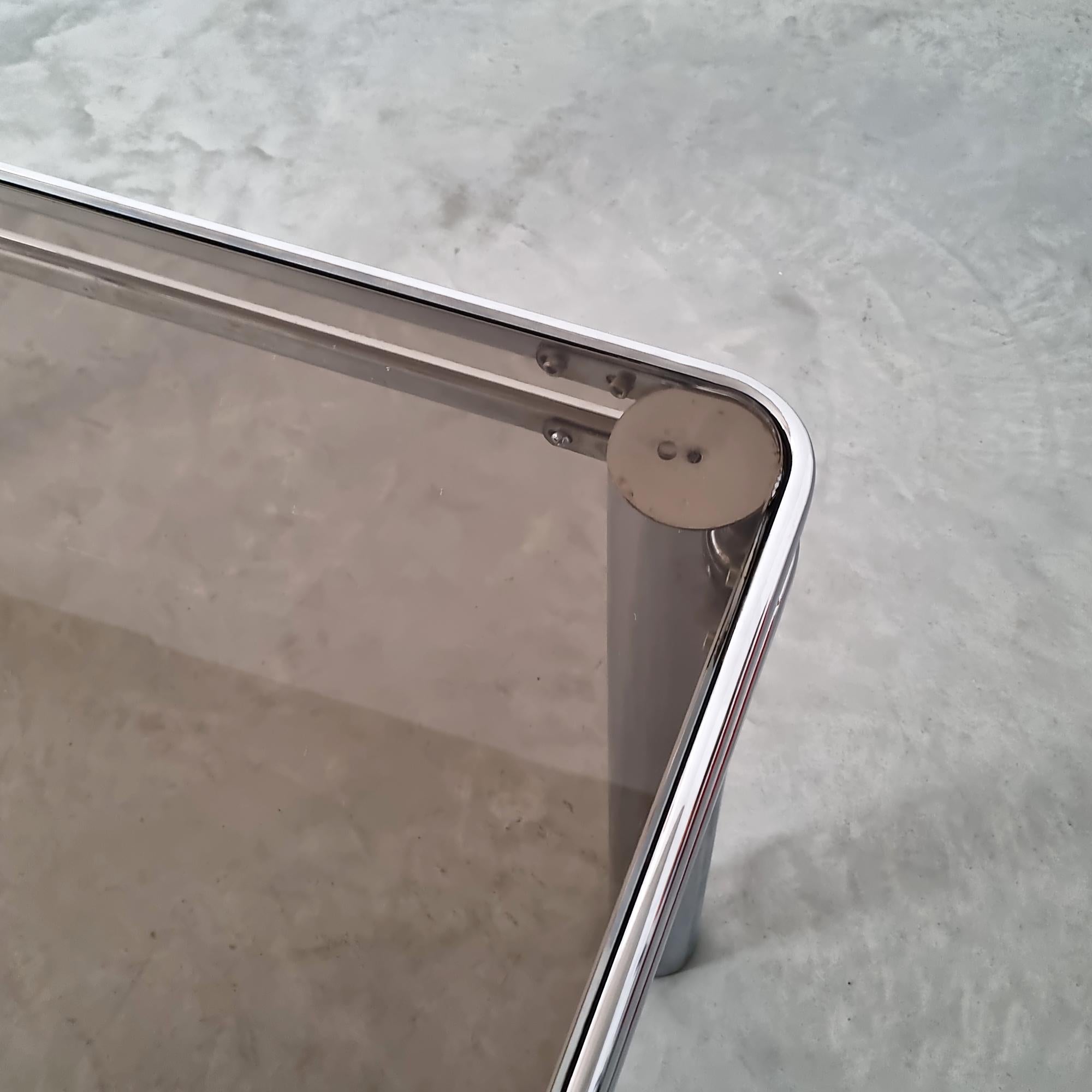 Vintage Midcentury Modern Italian Design Tubular Chrome & Smoke Glass Dining Table aus den 1970er Jahren. Dieser elegante Tisch besteht aus einem verchromten Stahlrohrgestell und einer Tischplatte aus Rauchglas. Es wurde in Italien hergestellt und