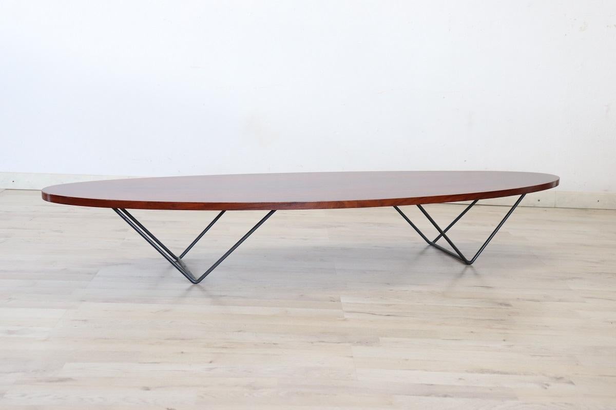 Dies ist ein schönes und anspruchsvolles Möbelstück aus der Mitte des Jahrhunderts. Das italienische Design der 60er Jahre ist bei diesem Couchtisch unverkennbar und offensichtlich.

Aus Holzfurnier gefertigt und durch eine langgestreckte ovale Form