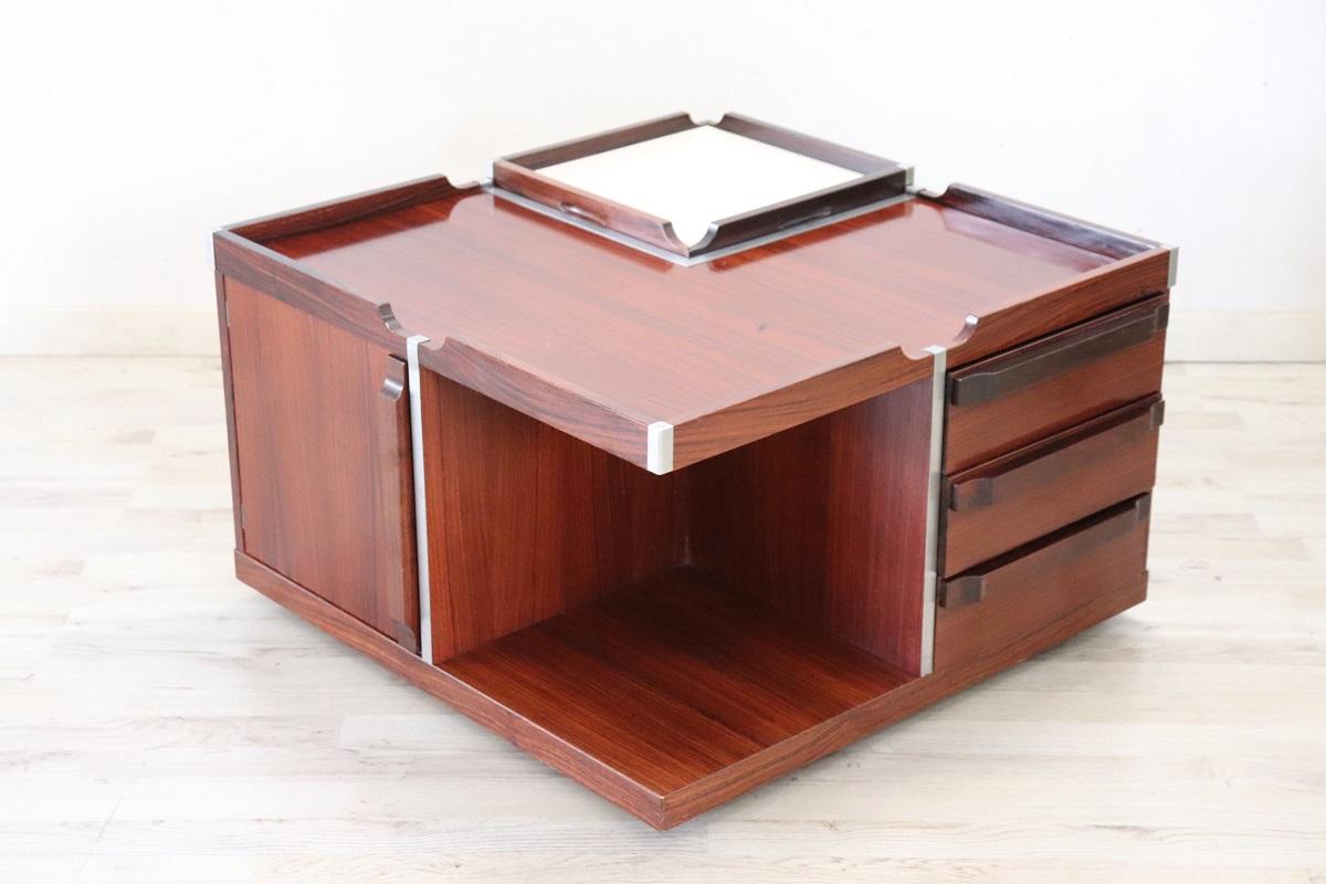 This is  a stunning and sophisticated piece of mid-century furniture. Italian design from the 60s often combines elegance with practicality, making this coffee table a great example of that tradition.

The combination of veneered teak wood and