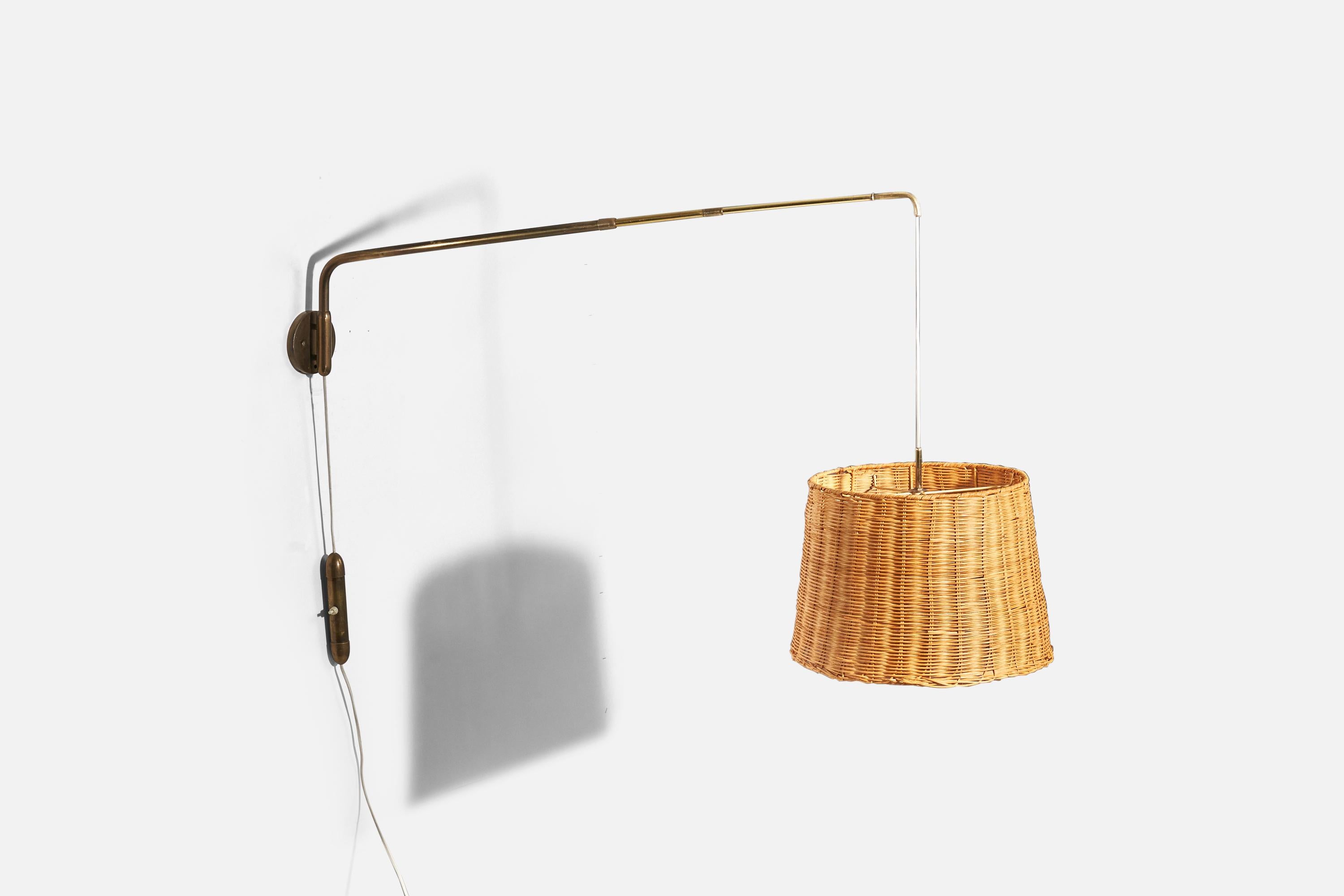 A brass and rattan wall light designed and produced in Italy, 1940s. 

Sold with Lampshade.
Dimensions stated refer to the lamp with the shade. 
Variable dimensions, measured as illustrated in the first image. 
Dimensions of back plate
