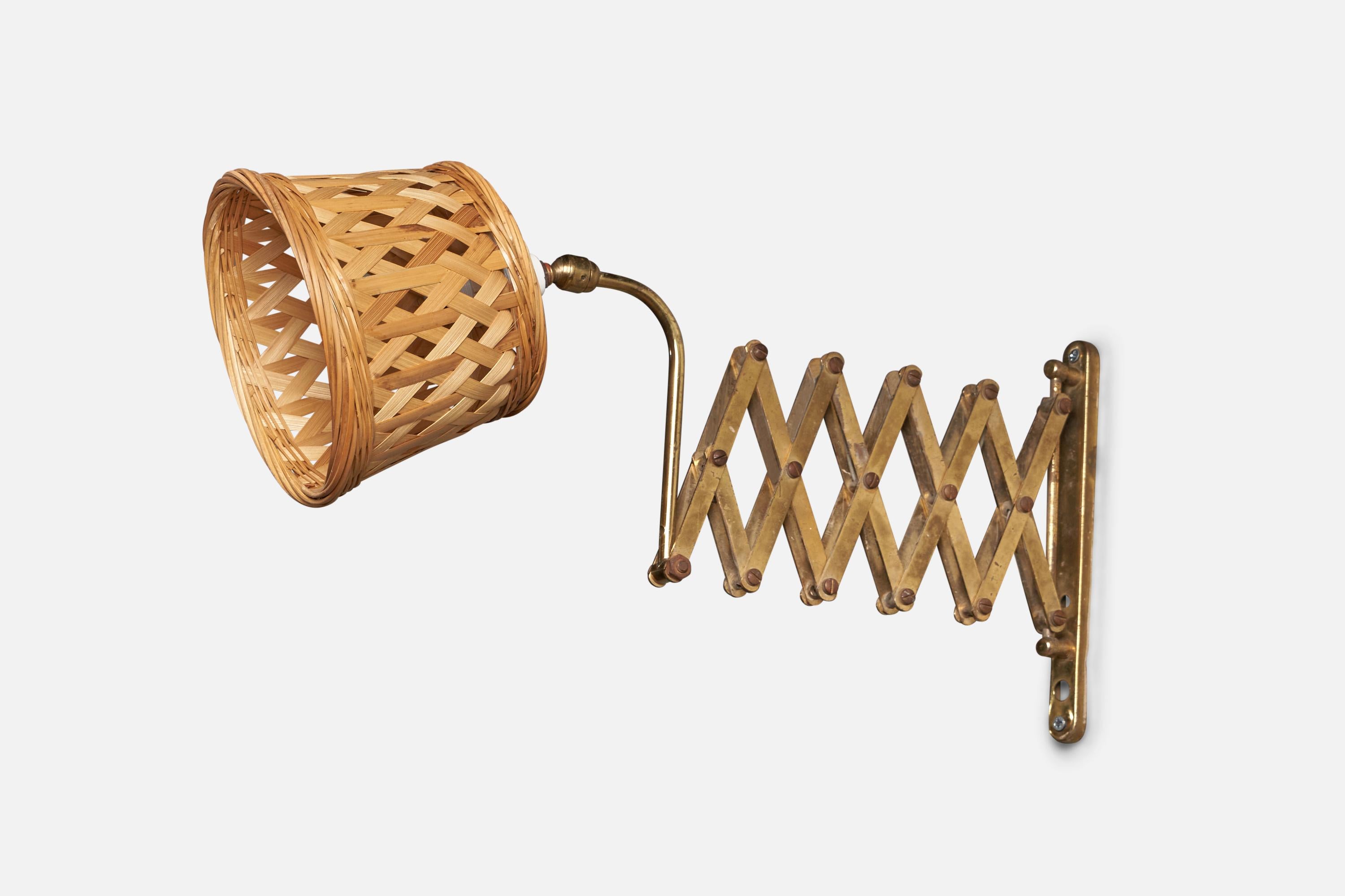 An adjustable rattan and brass wall light, designed and produced in Italy, 1940s.

Overall Dimensions: 9.5