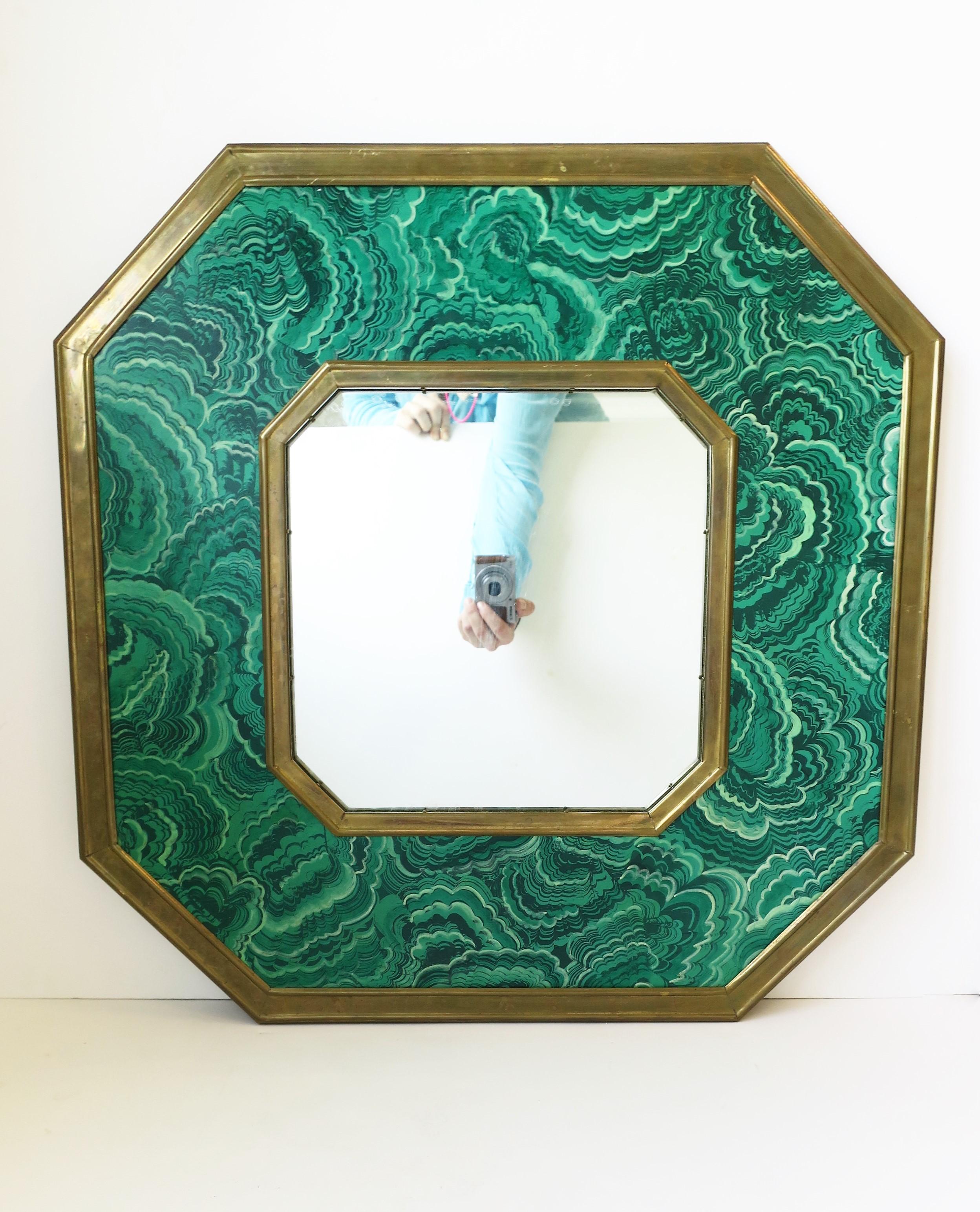 A beautiful Italian brass and green malachite resin octagonal mirror designed by Sarried Ltd., circa 1970s, Italy. Mirror has a brass and green malachite resin frame in an octagonal shape (a nice alternative to round.) With authentication maker's