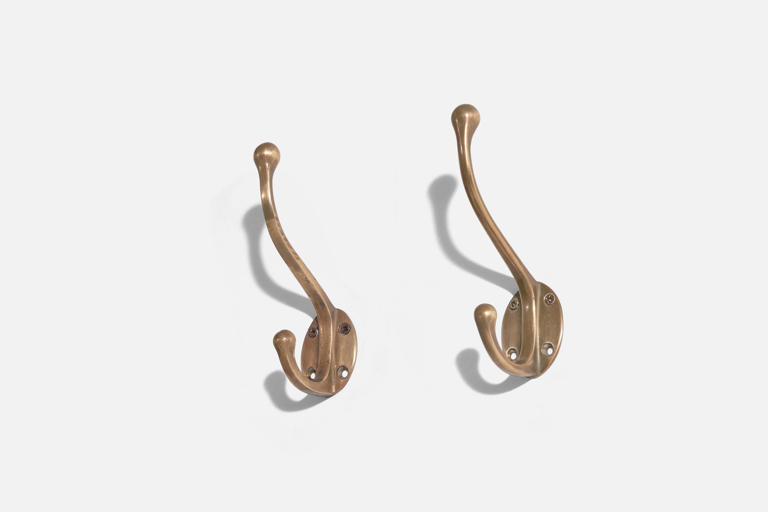 A pair of brass coat hangers, designed and produced by an Italian designer, Italy, 1940s.