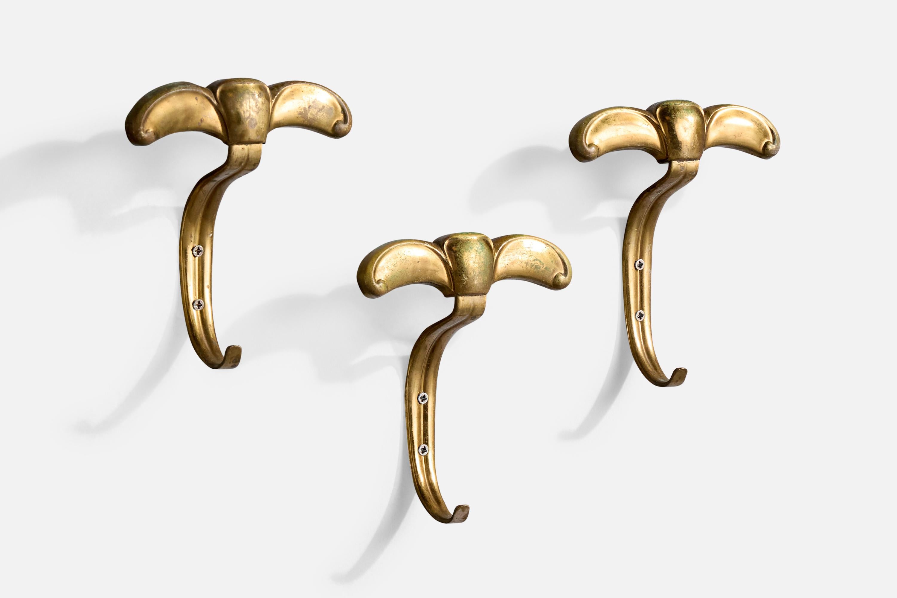 A set of three brass coat hangers designed and produced in Italy, c. 1950s.

Dimensions: 6” H x 5.5” W x 2.125” D