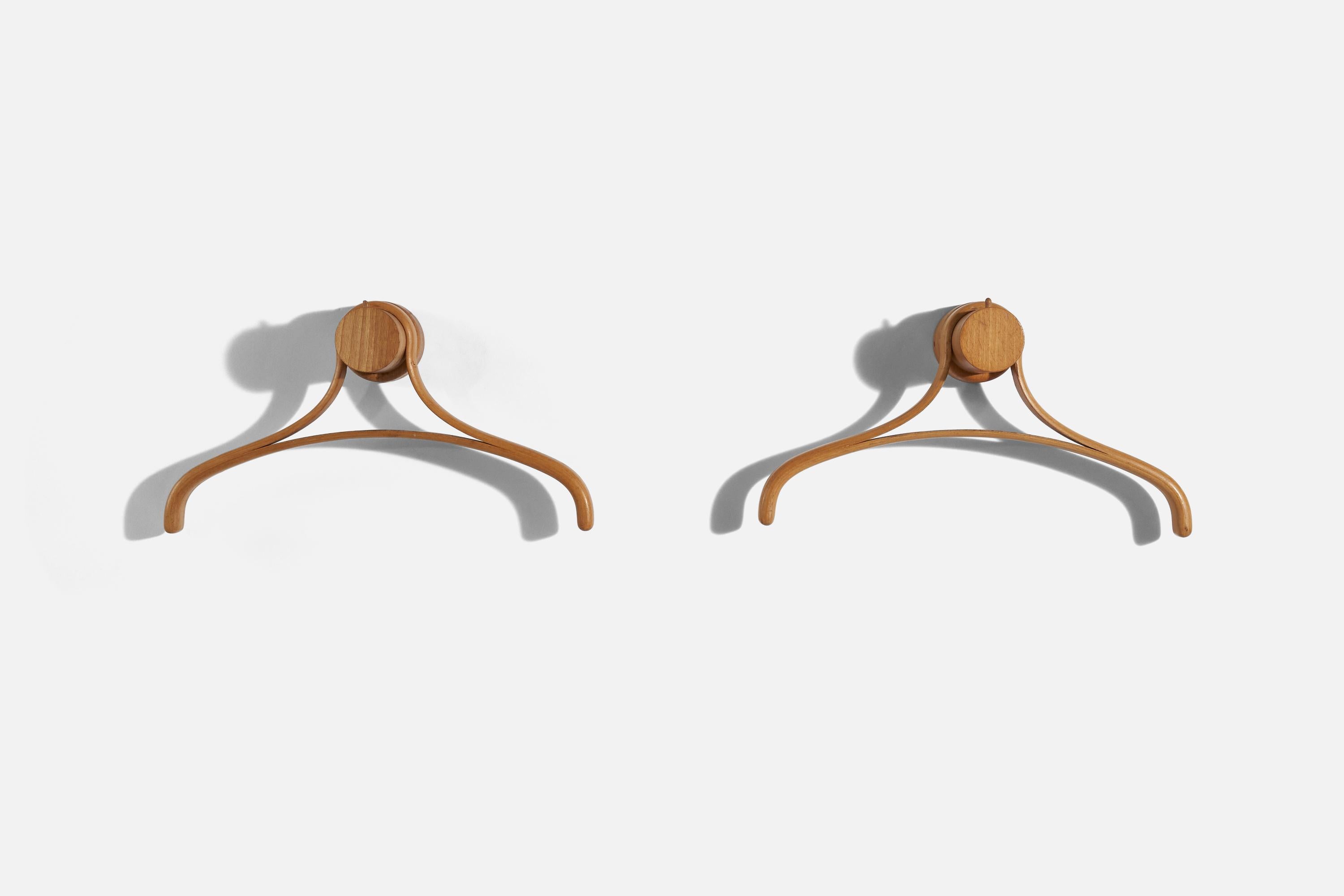 A pair of oak coat hangers, designed and produced by an Italian designer, Italy, 1960s.