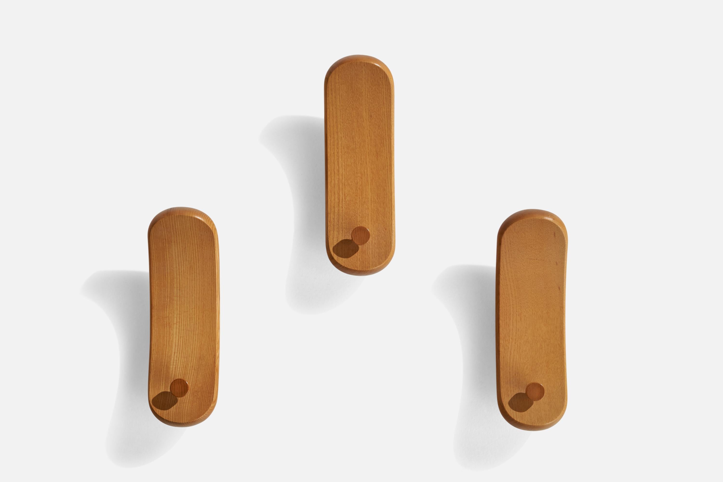 A set of 3 oak coat hangers designed and produced in Italy, 1970s.