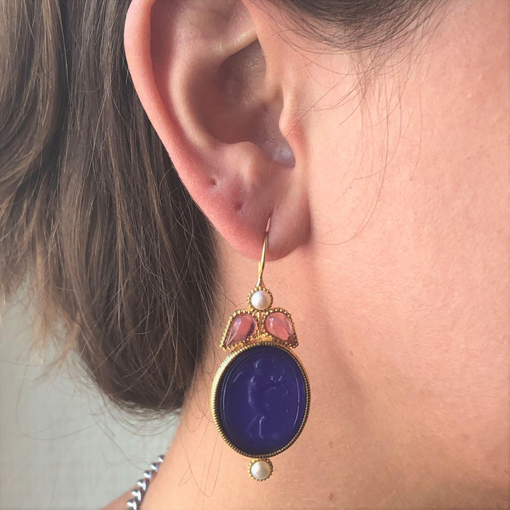 For pierced ears.
Pair of pendant earrings in vermeil, silver and yellow gold.
Each vermeil ear pendant is set with an intaglio on glass paste, glass pearls and cabochon-cut crystals. The attachment is a gooseneck with safety hook.
Total length :