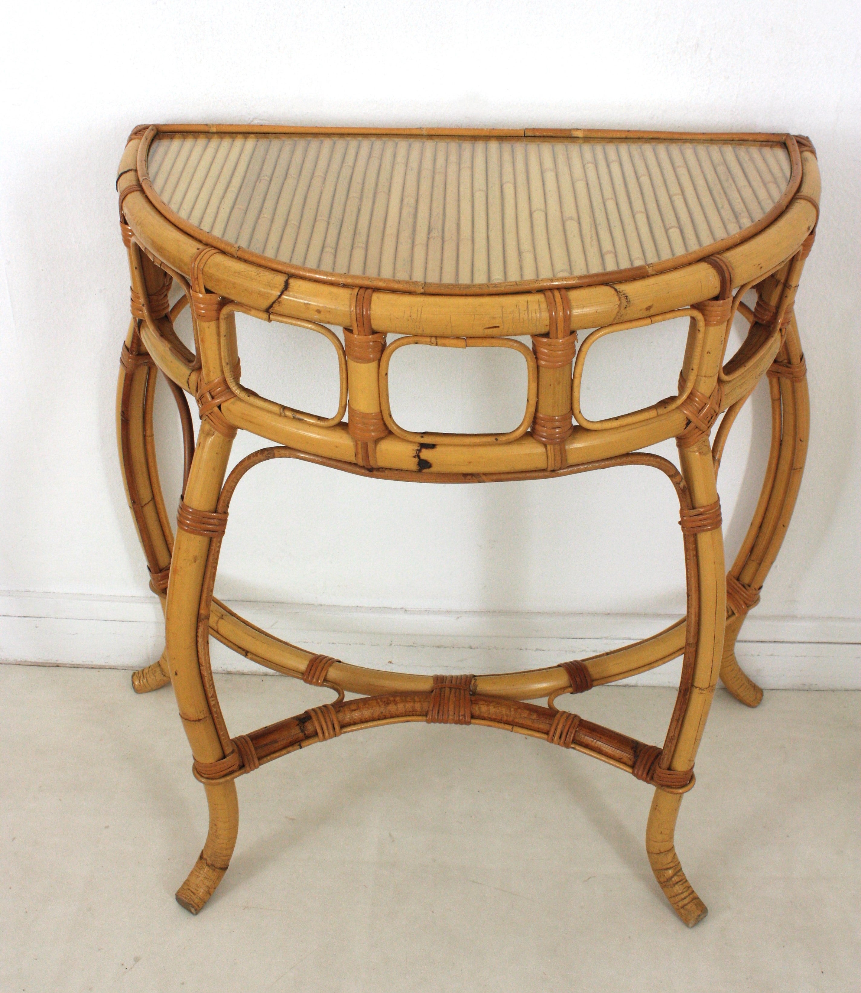 Auffälliger Konsolentisch aus Bambus und Rattan mit Bogen. Im Stil von Franco Albini, Bonacina, Crespi und Vivai del Sud. Italien, 1960er Jahre.
Dieser Konsolentisch steht auf drei Bambusbeinen, die durch eine kreuzförmige Streckung miteinander