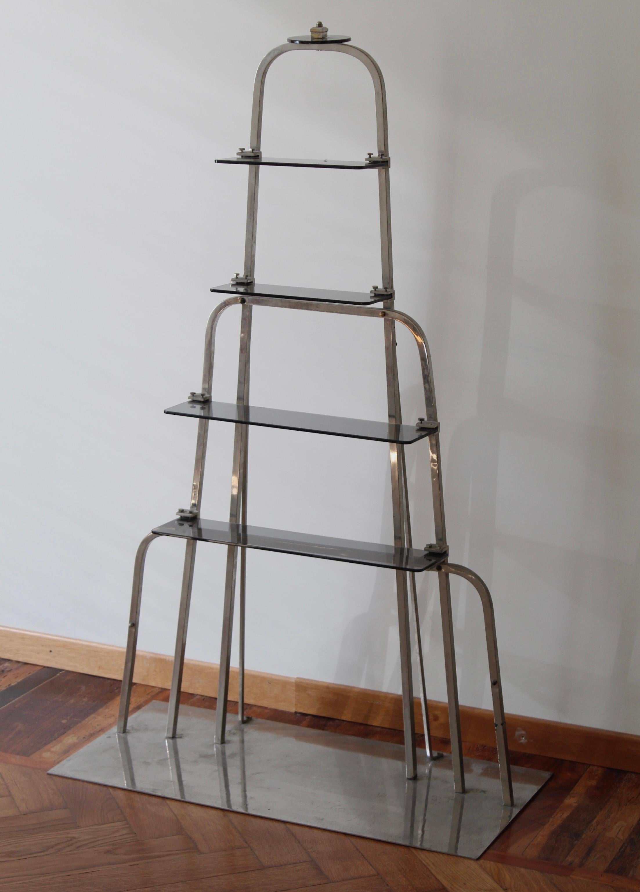 A small bookcase or etagere, designed and produced in Italy, 1940s. Executed in chrome-plated metal and smoked glass, originally a commission piece for a retail space in Milano.