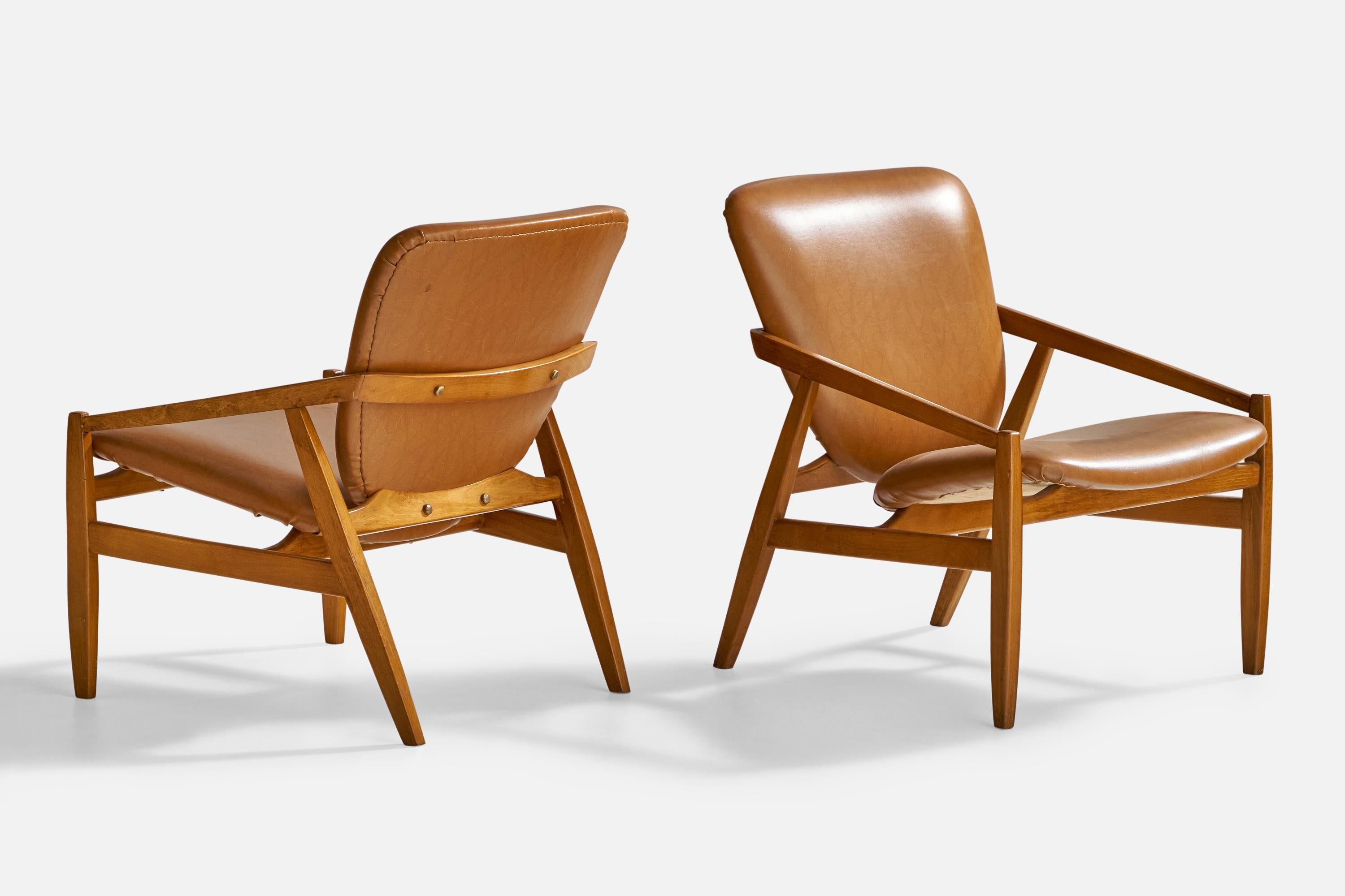 A pair of walnut and brown leatherette lounge chairs designed and produced in Italy, 1950s.

Seat height: 14.5”