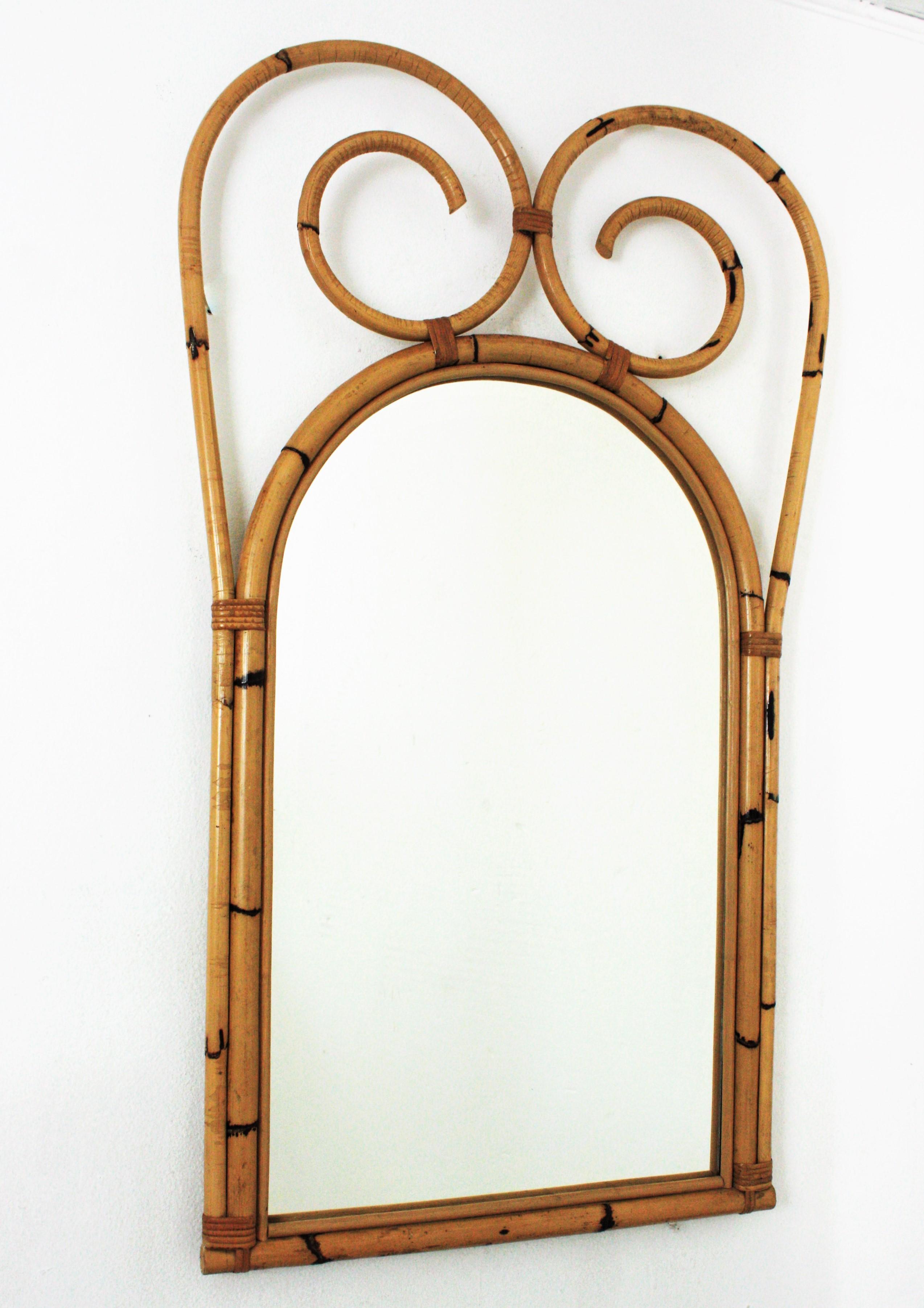 Hervorragender großer Rattan-Bambus-Spiegel aus der Mitte des Jahrhunderts. Italienische Herstellung, 1950er-1960er Jahre
Dieser coole Wandspiegel besteht aus einem gewölbten Bambusspiegel, der mit einem großen, spiralförmigen Wappen aus