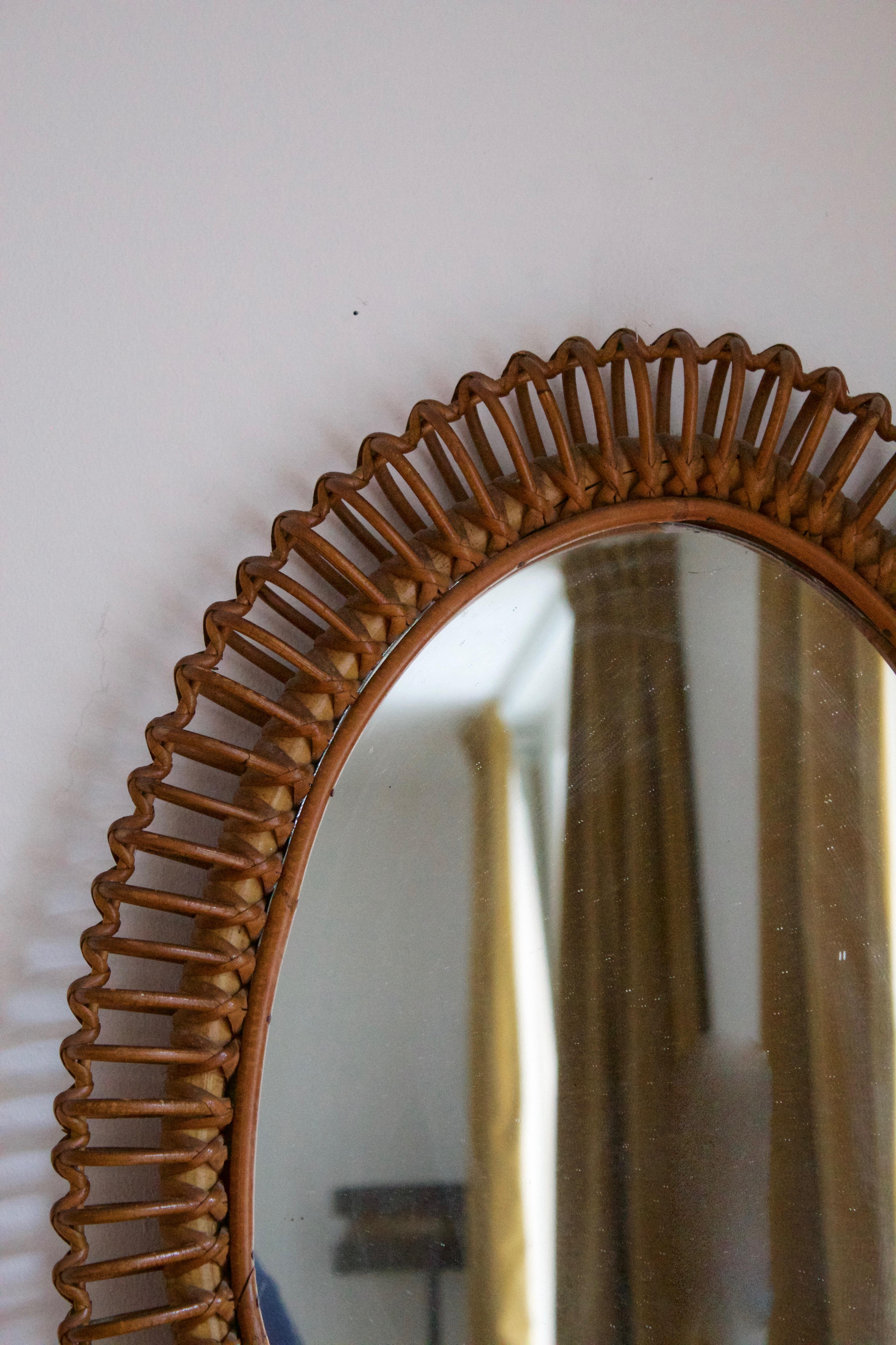 A wall mirror, produced in Italy, 1950s. Cut mirror glass is framed in rattan.

Other designers of the period include Gio Ponti, Fontana Arte, Max Ingrand, Franco Albini, and Josef Frank.