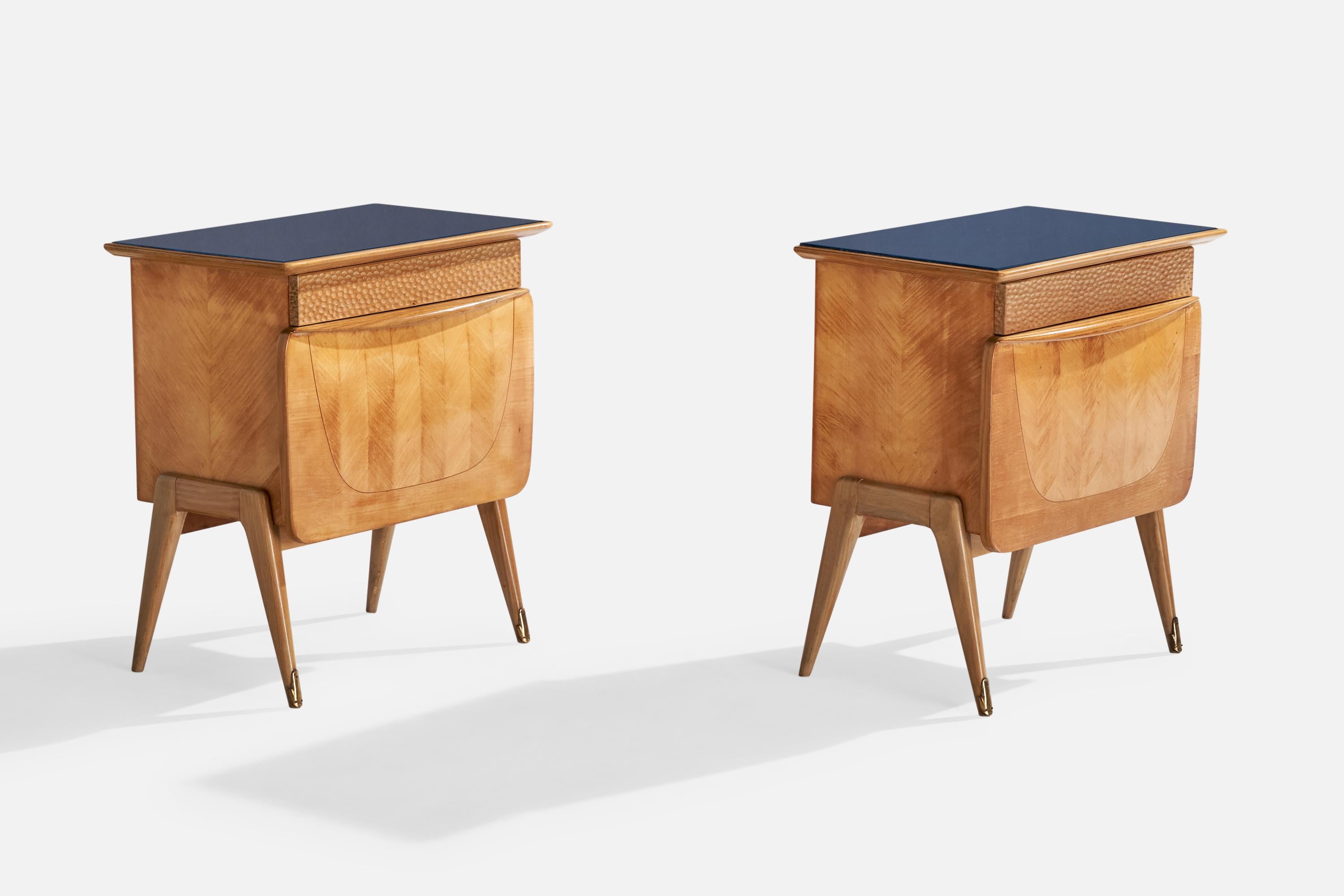 A pair of wood, brass and blue-colored glass nightstands designed and produced in Italy, c. 1950s.