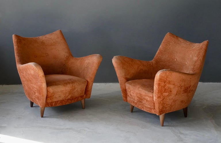 A pair of organic lounge chairs. Designed and produced in Italy, 1950s. Features an overstuffed form on wooden legs. Vintage fabric. 

Other designers of the period include Guglielmo Veronesi, Federico Munari, Gio Ponti, Franco Albini, and Paolo