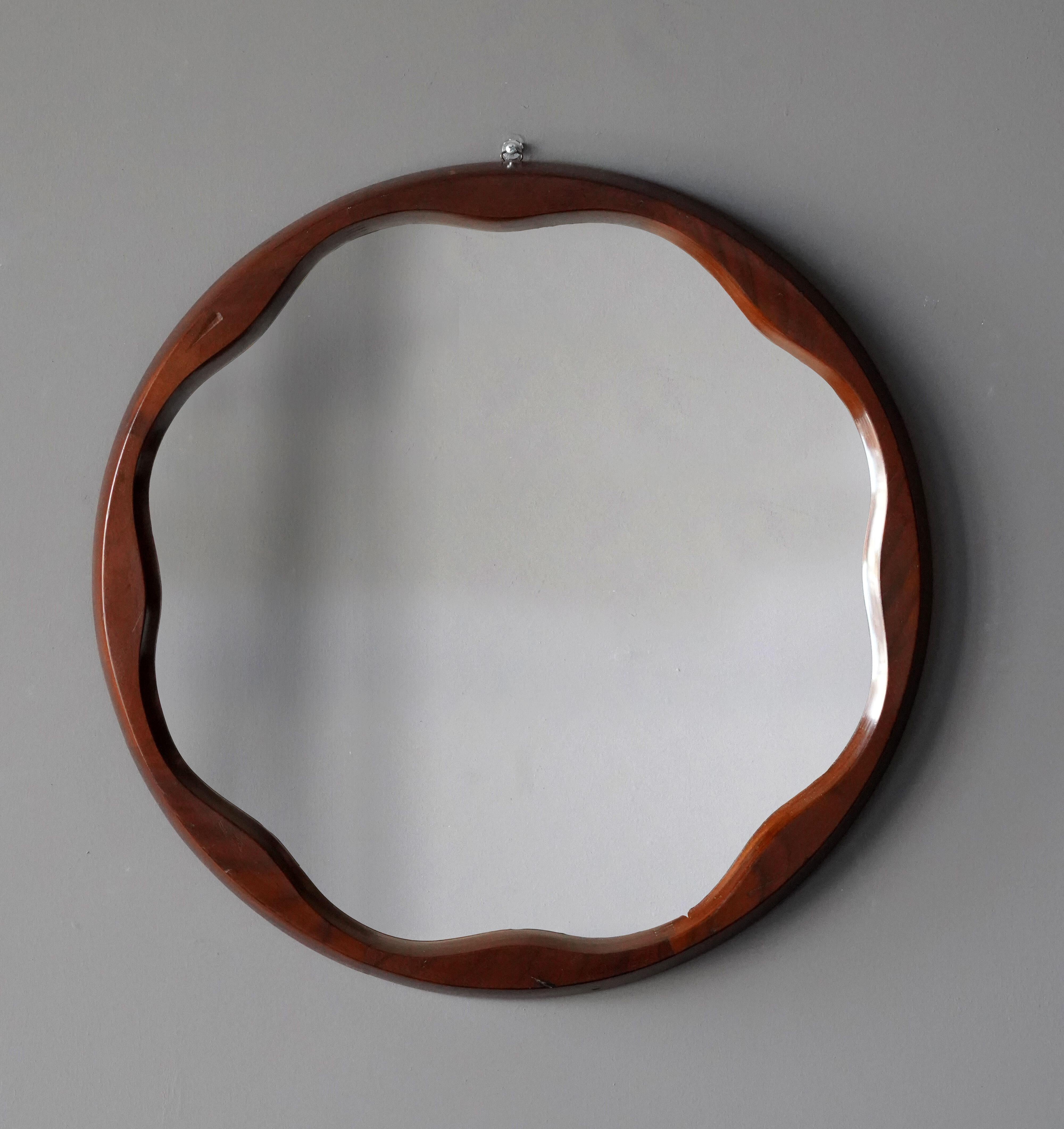 An organic wall mirror, produced in Italy, 1950s. Cut mirror glass is framed in finely sculpted walnut frame.

Other designers of the period include Gio Ponti, Fontana Arte, Paolo Buffa, Franco Albini, and Jean Royere.