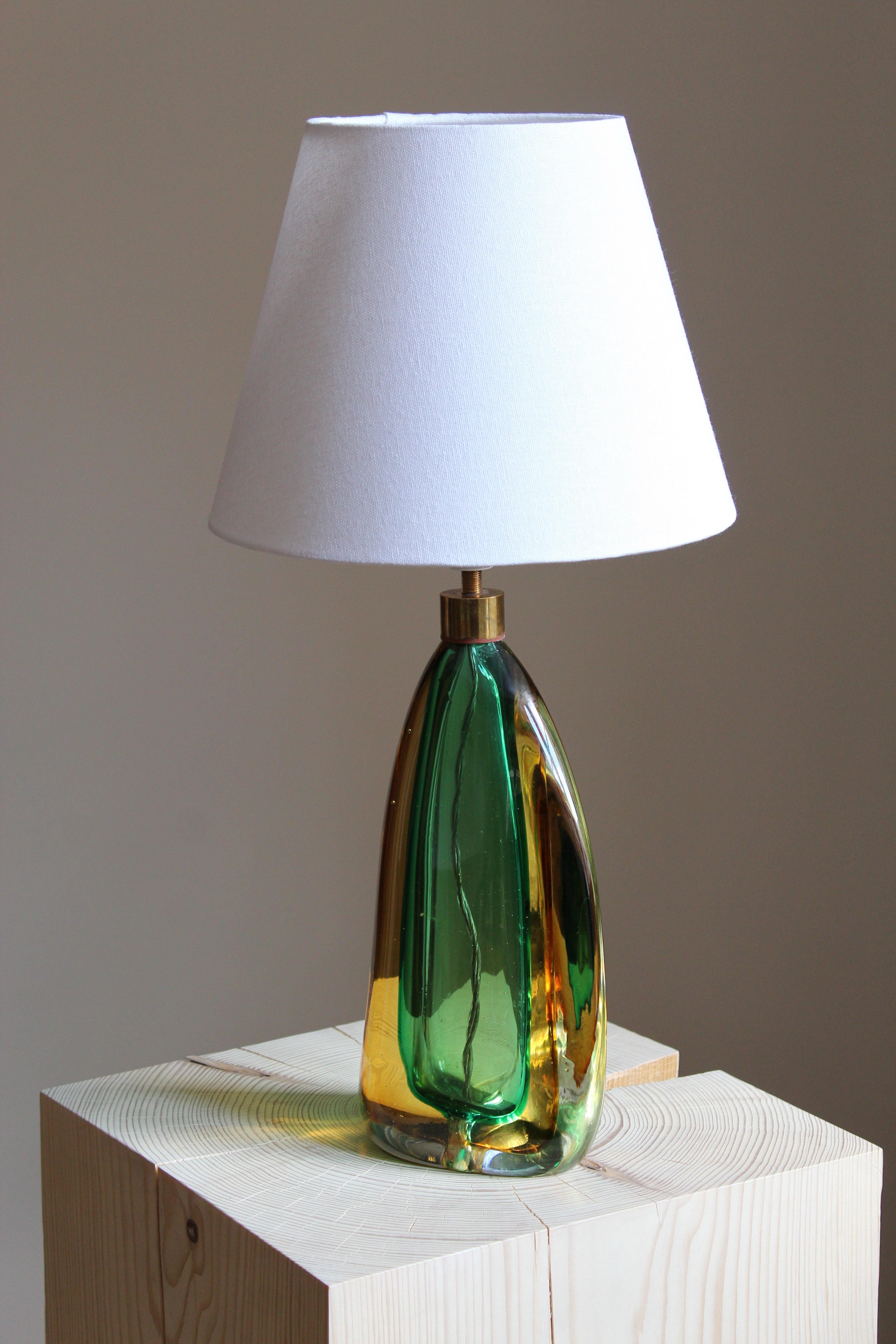 An organic table lamp. By an unknown Italian designer, produced in Italy, c. 1960s. Sourced in Denmark where this and similar lamps were retailed during the period.

Produced in colored Murano-glass and brass.

Sold without lampshade, stated