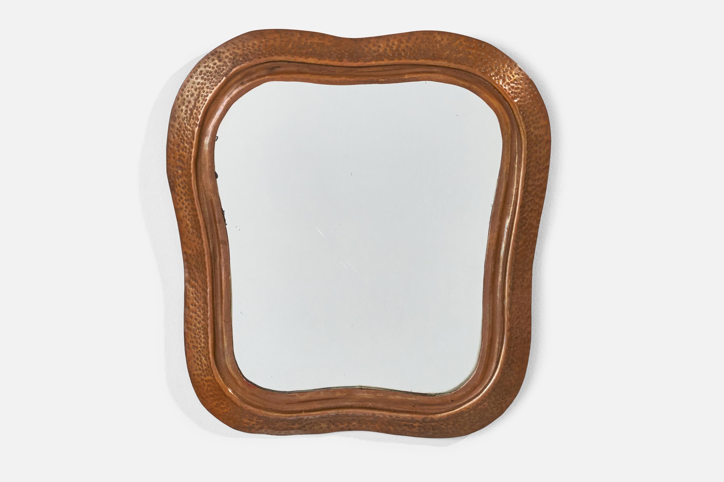 A hammered copper wall mirror designed and produced in Italy, 1940s.