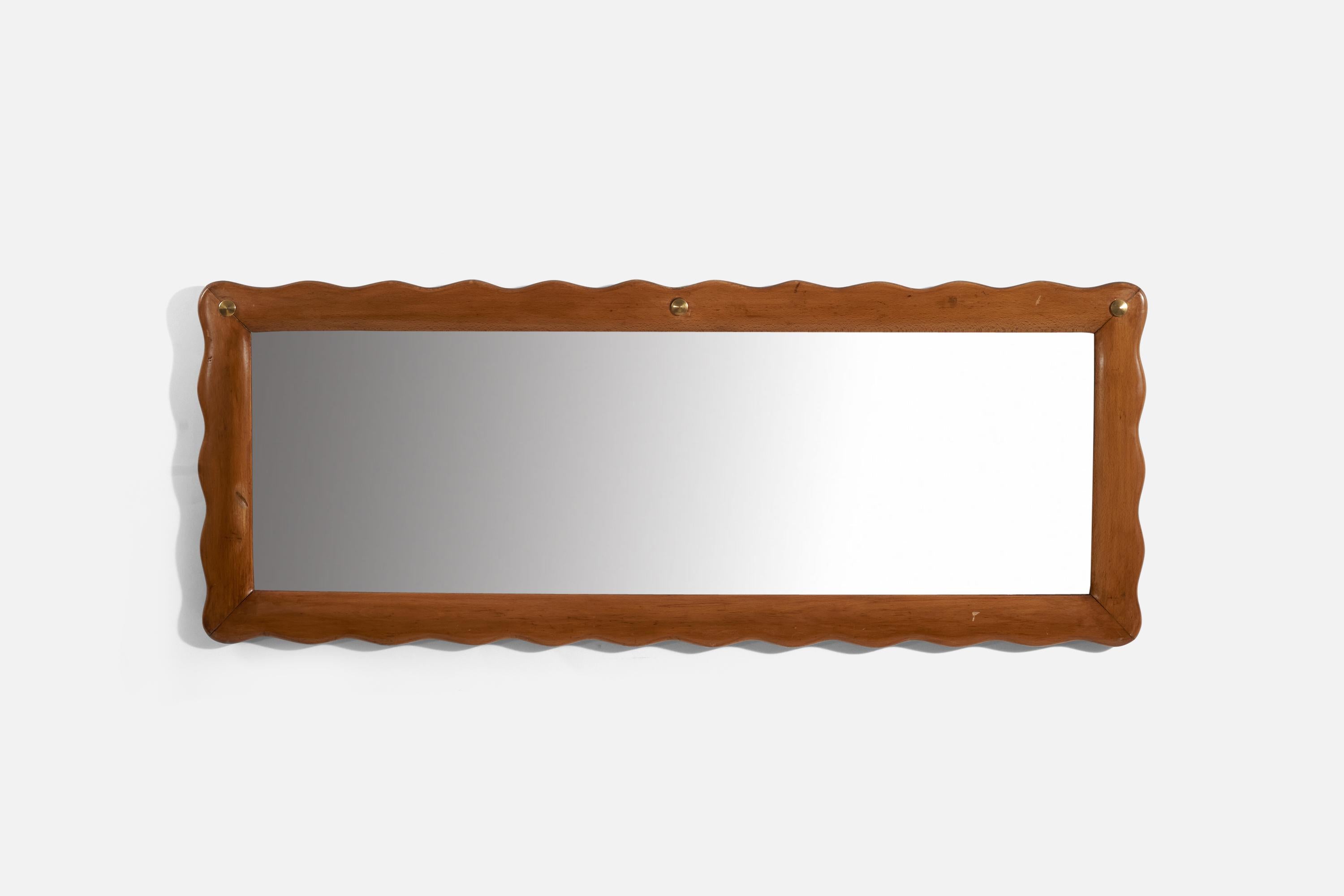 A carved wood and brass wall mirror produced in Italy, 1940s.
 
