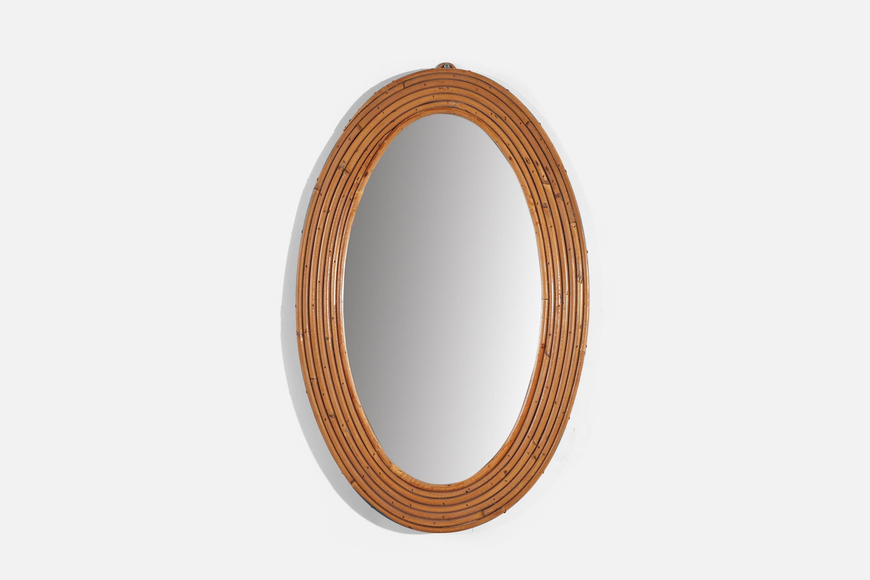 An oval, bamboo wall mirror designed and produced in Italy, c. 1950s-1960s. 
 